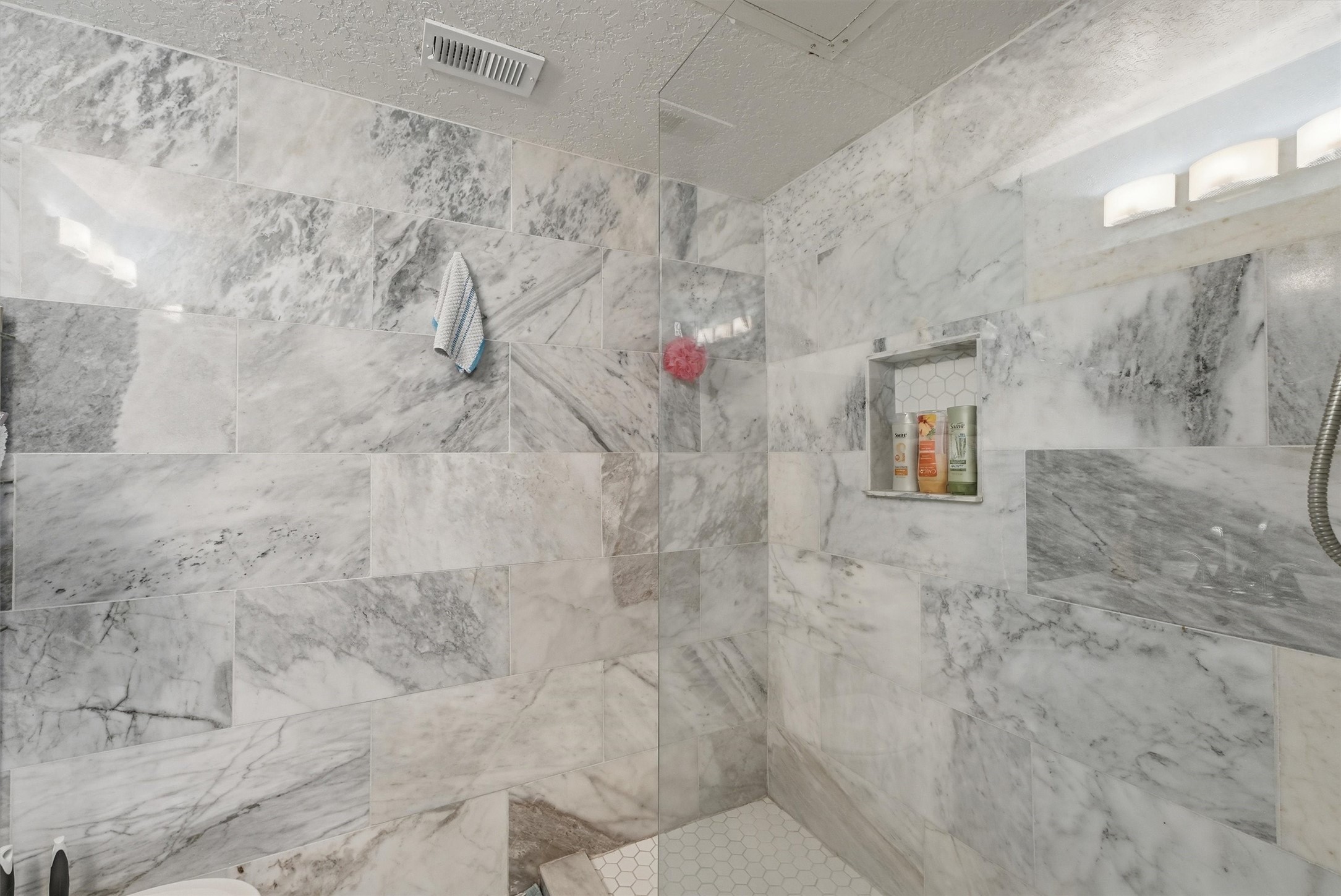 Walk-in shower finished in marble-look tile