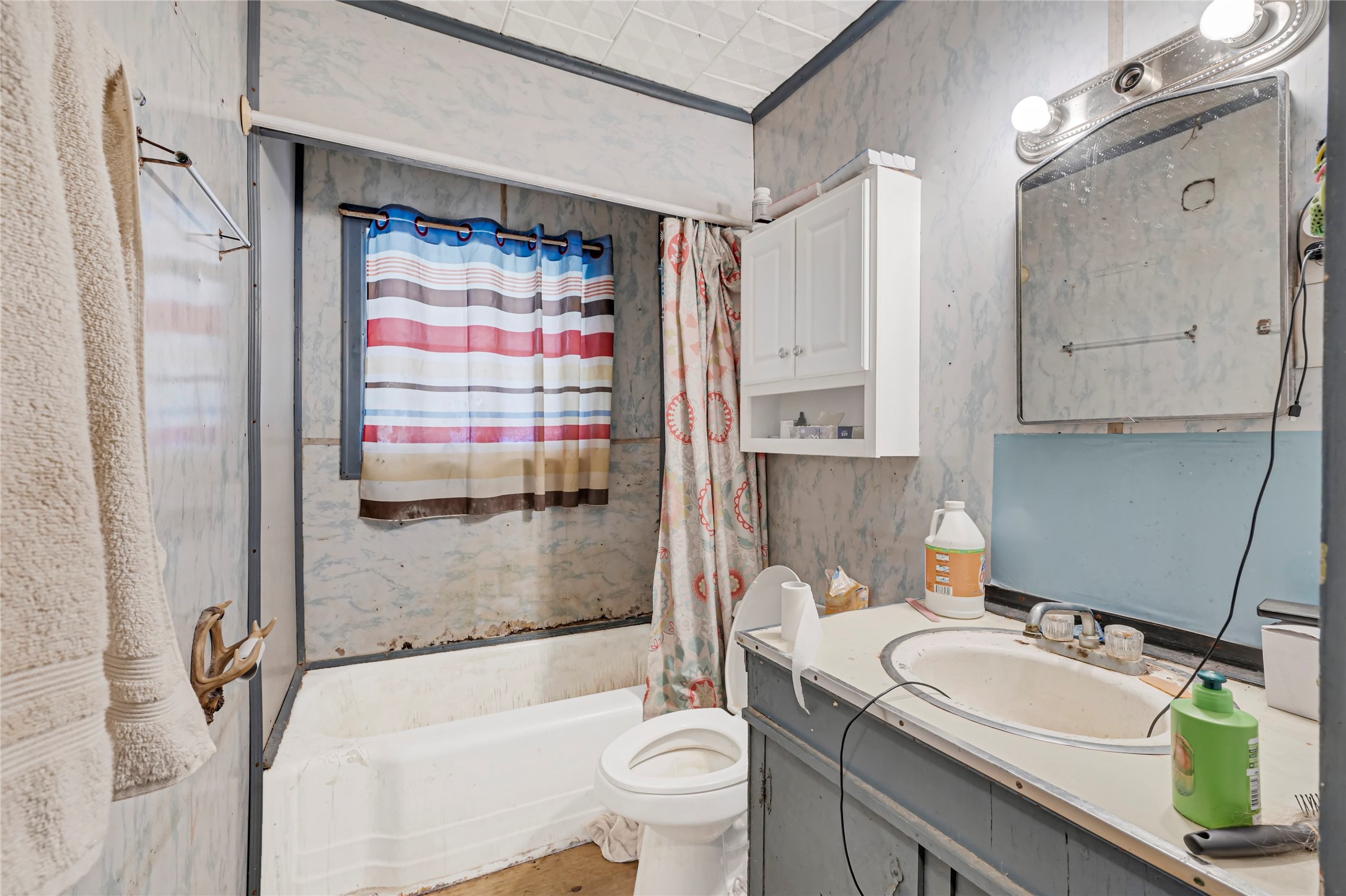 Cozy bathroom with vintage charm, featuring a tub-shower combo and ample cabinet storage for your essentials.