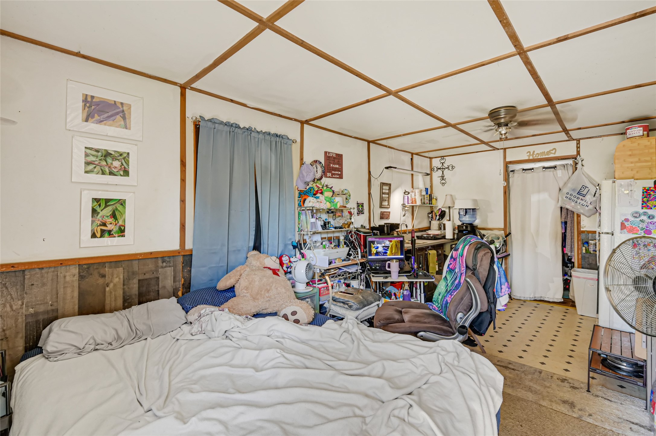 Cozy bedroom with rustic wood accents, featuring a comfortable bed and ample space for a home office setup.