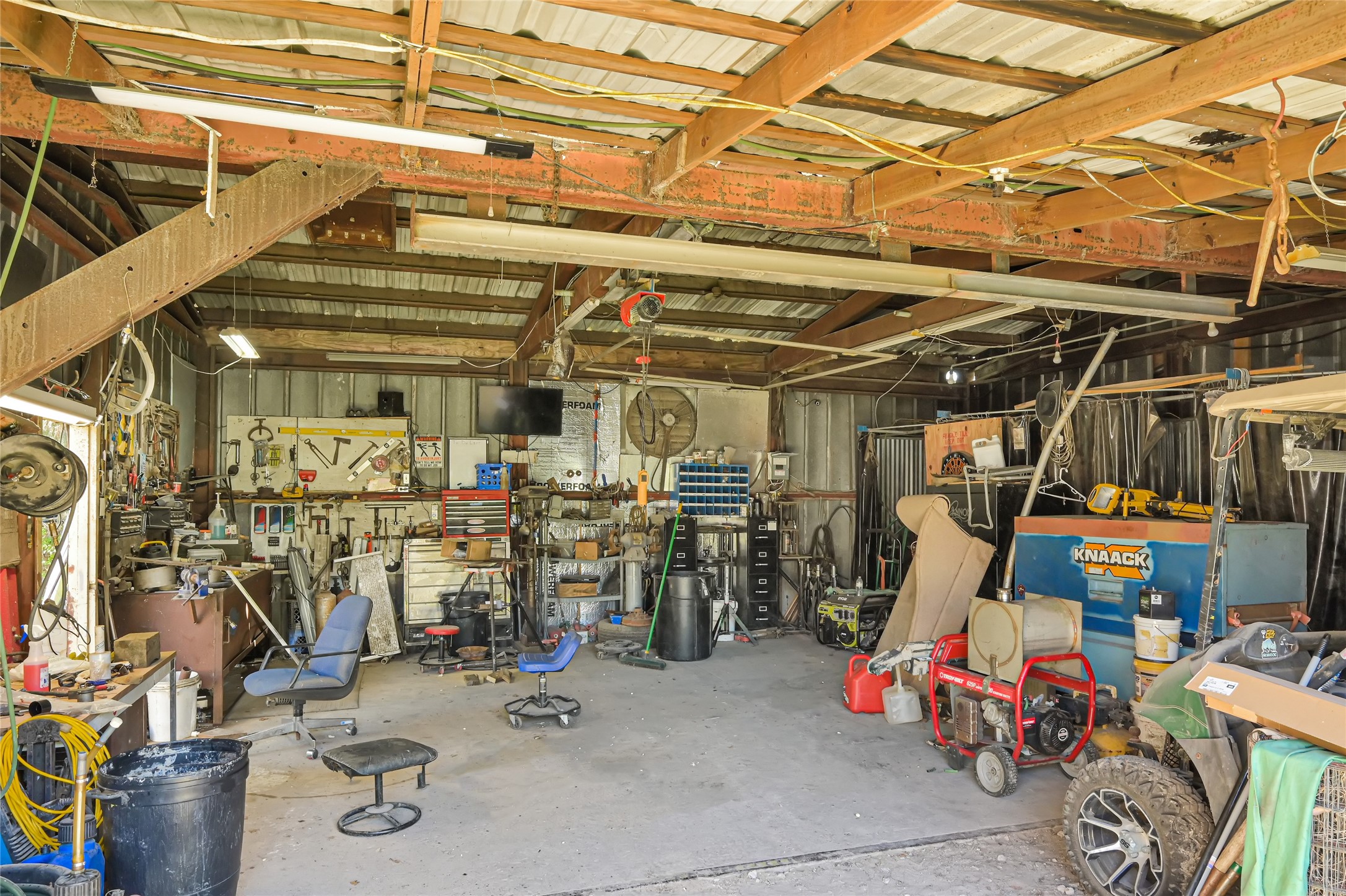 Spacious workshop featuring ample room for projects, equipped with tools, storage solutions, and workbenches, ideal for DIY enthusiasts or professional use.