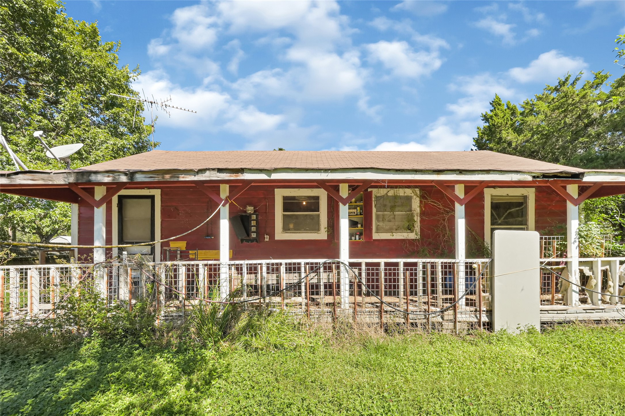 Charming rustic home with a spacious front porch, set amidst lush greenery for a serene retreat.