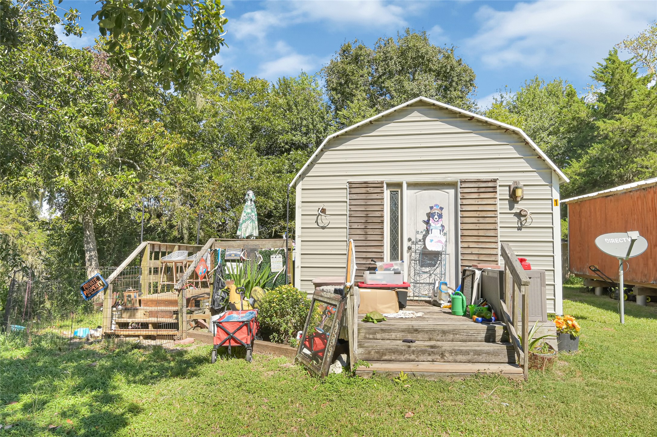 Charming rustic cottage surrounded by lush greenery, featuring a cozy porch perfect for outdoor relaxation and entertainment.