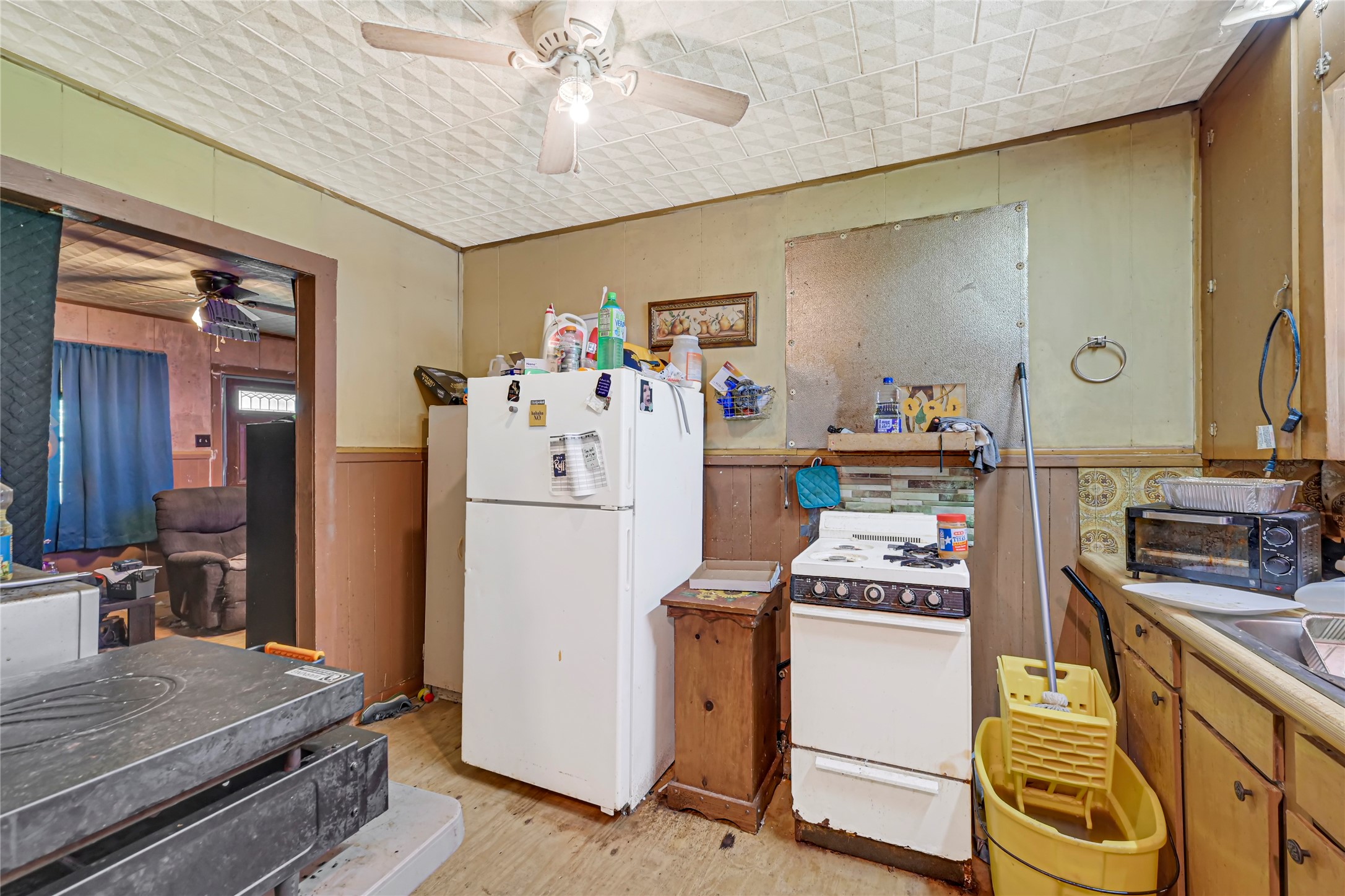 Cozy kitchen space with vintage charm, featuring a classic gas stove, ample cabinetry, and adjoining living area.