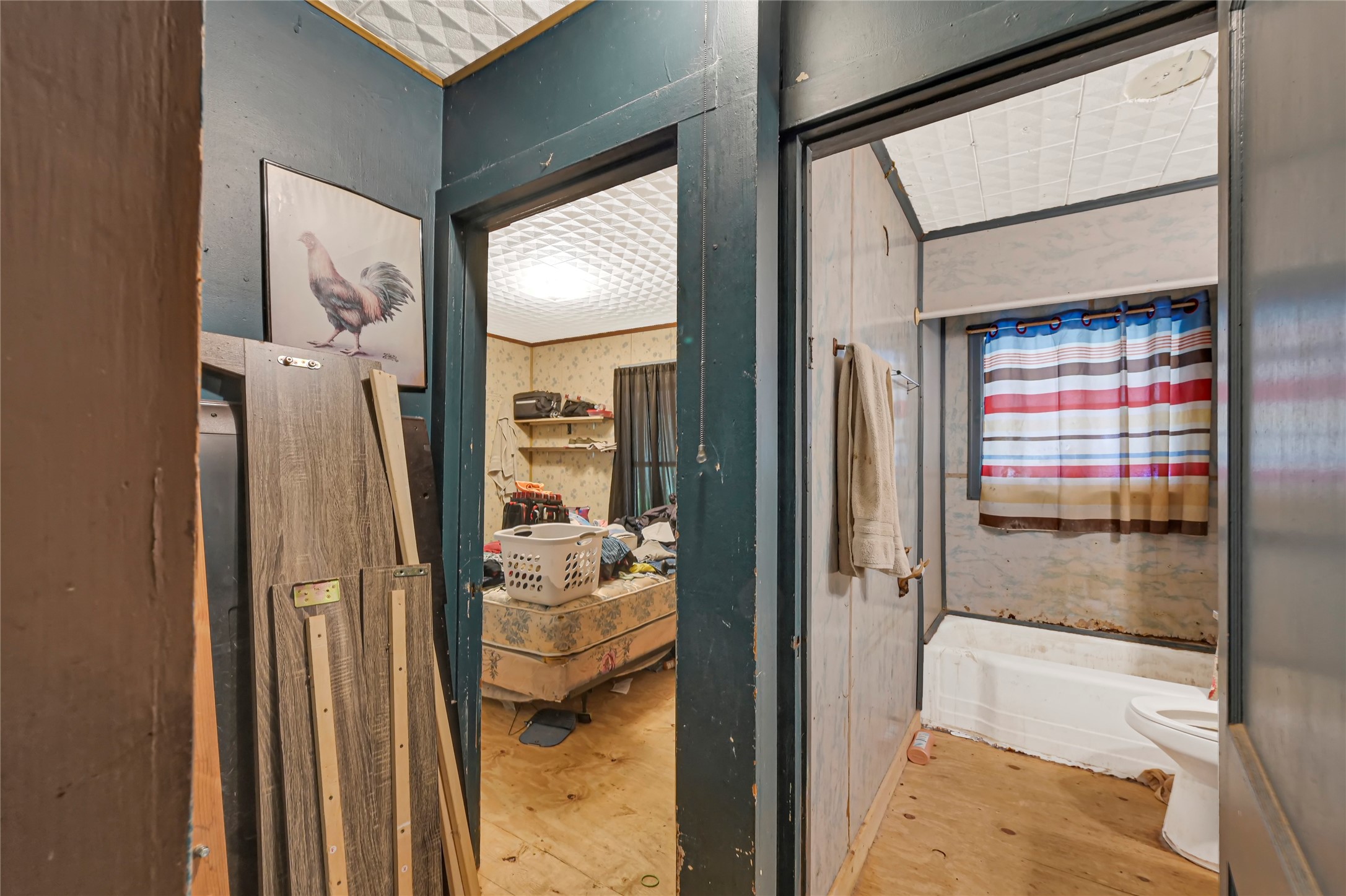 Cozy space with potential, featuring a bathroom with a tub and shower combination, complemented by a nearby room ready for customization or renovation.