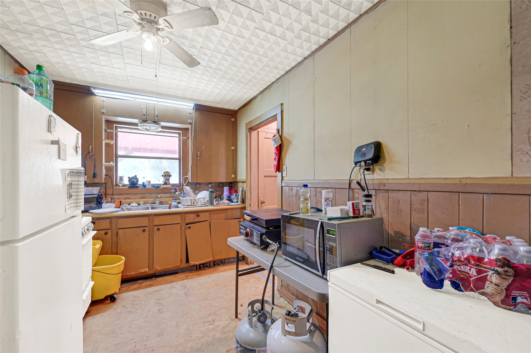 Cozy kitchen with rustic wooden cabinets, ample natural light, and a functional layout perfect for customization.
