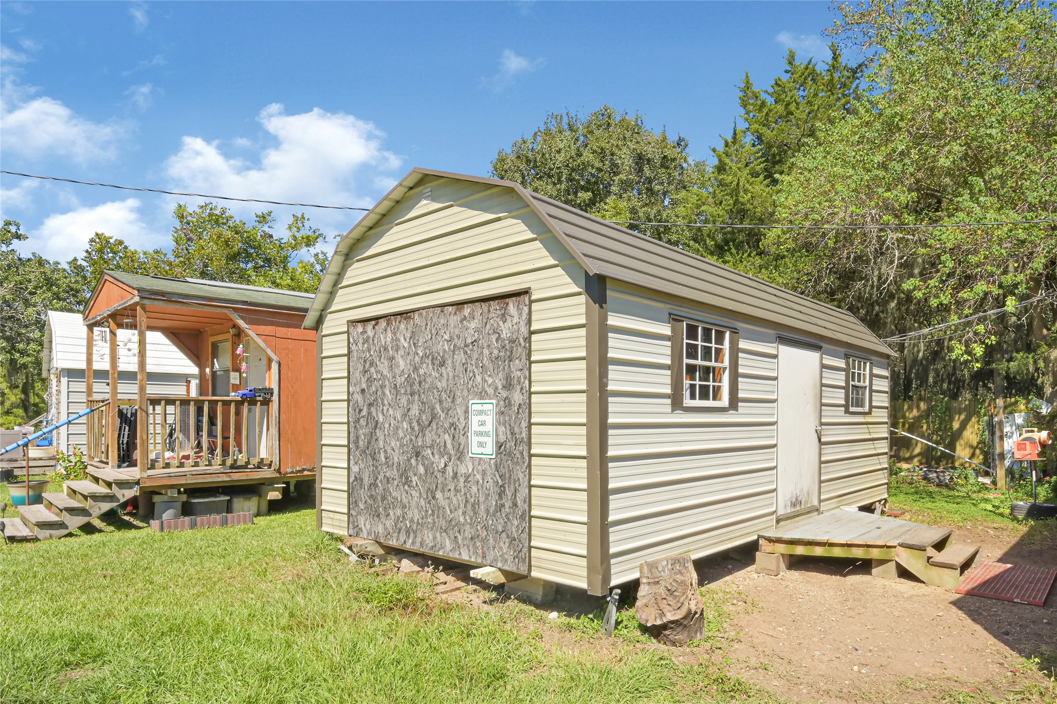 Spacious storage shed with a classic metal roof and windows, perfect for extra storage or a workshop, set on a lush, green lawn.