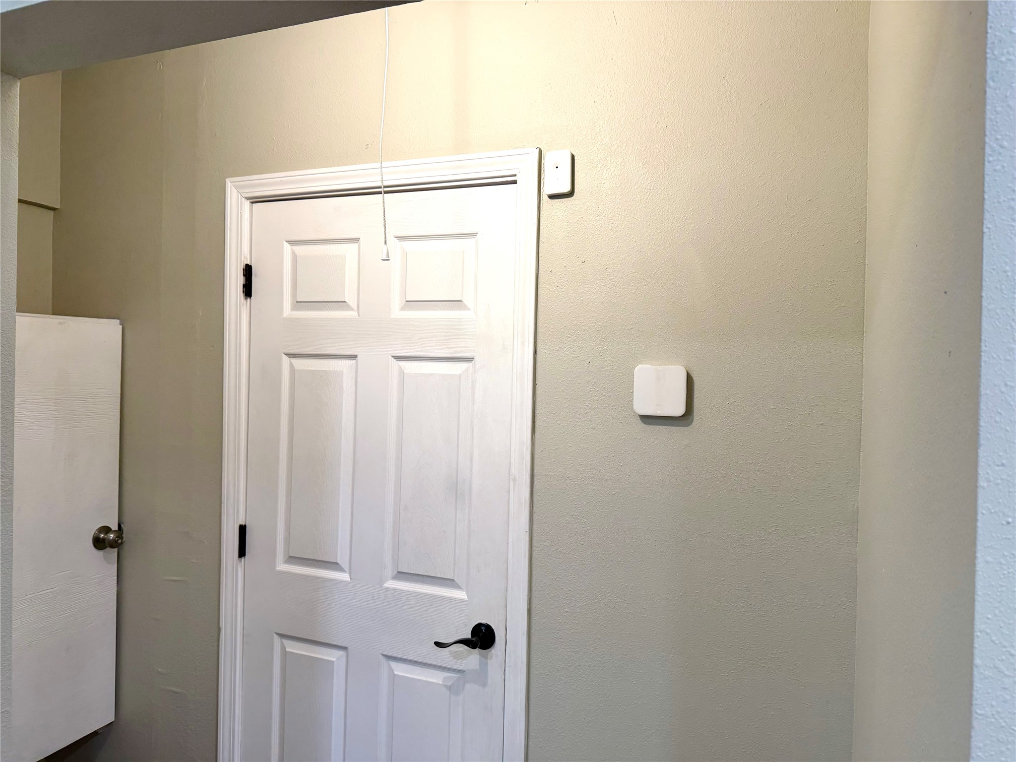 Hall for bath entry. Thermostat for central heat and air.
