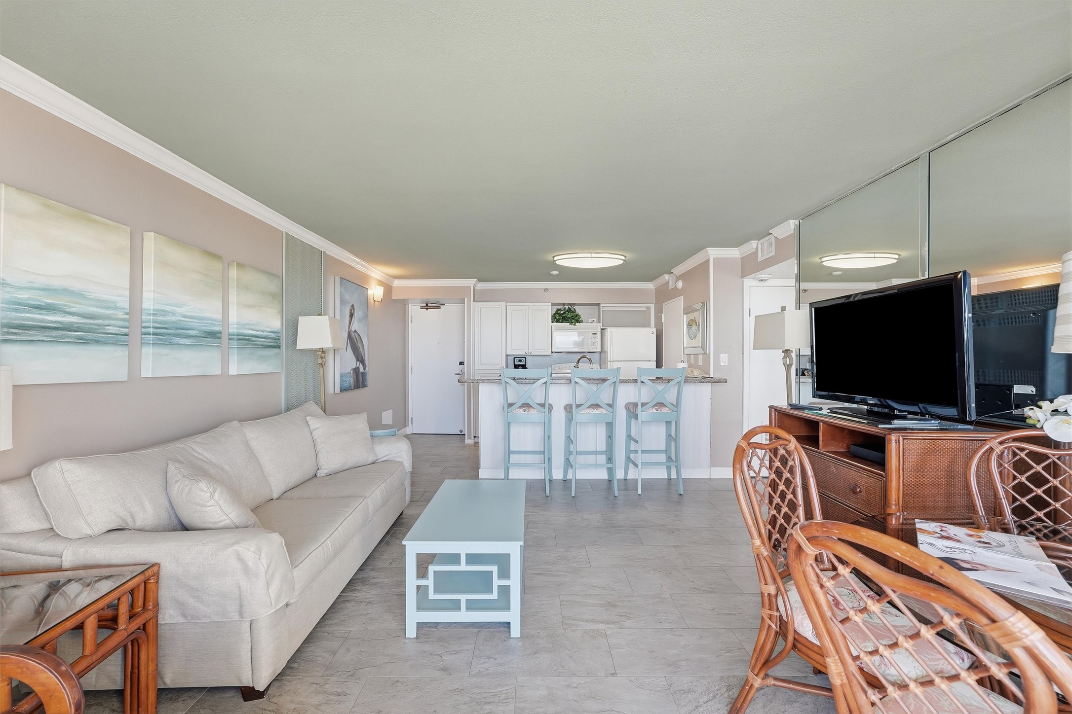 Tile flooring and soft coastal colors flow throughout the open living and kitchen areas.