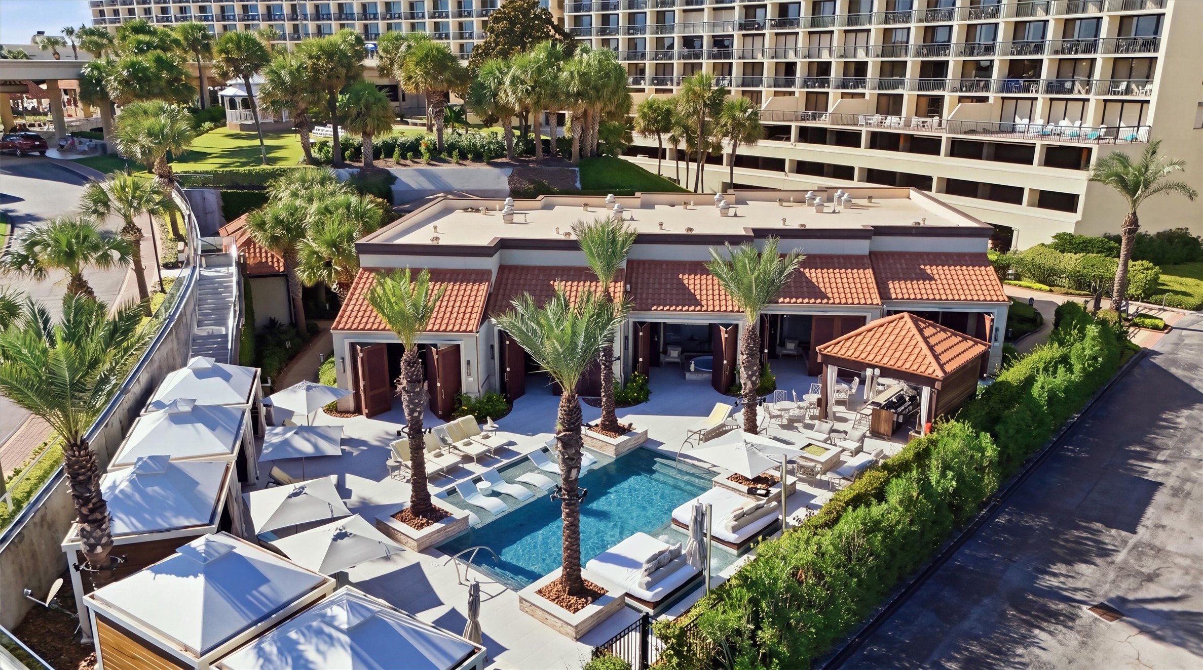 Poolside cabanas and shaded lounging spaces create a relaxing retreat for sunny afternoons.