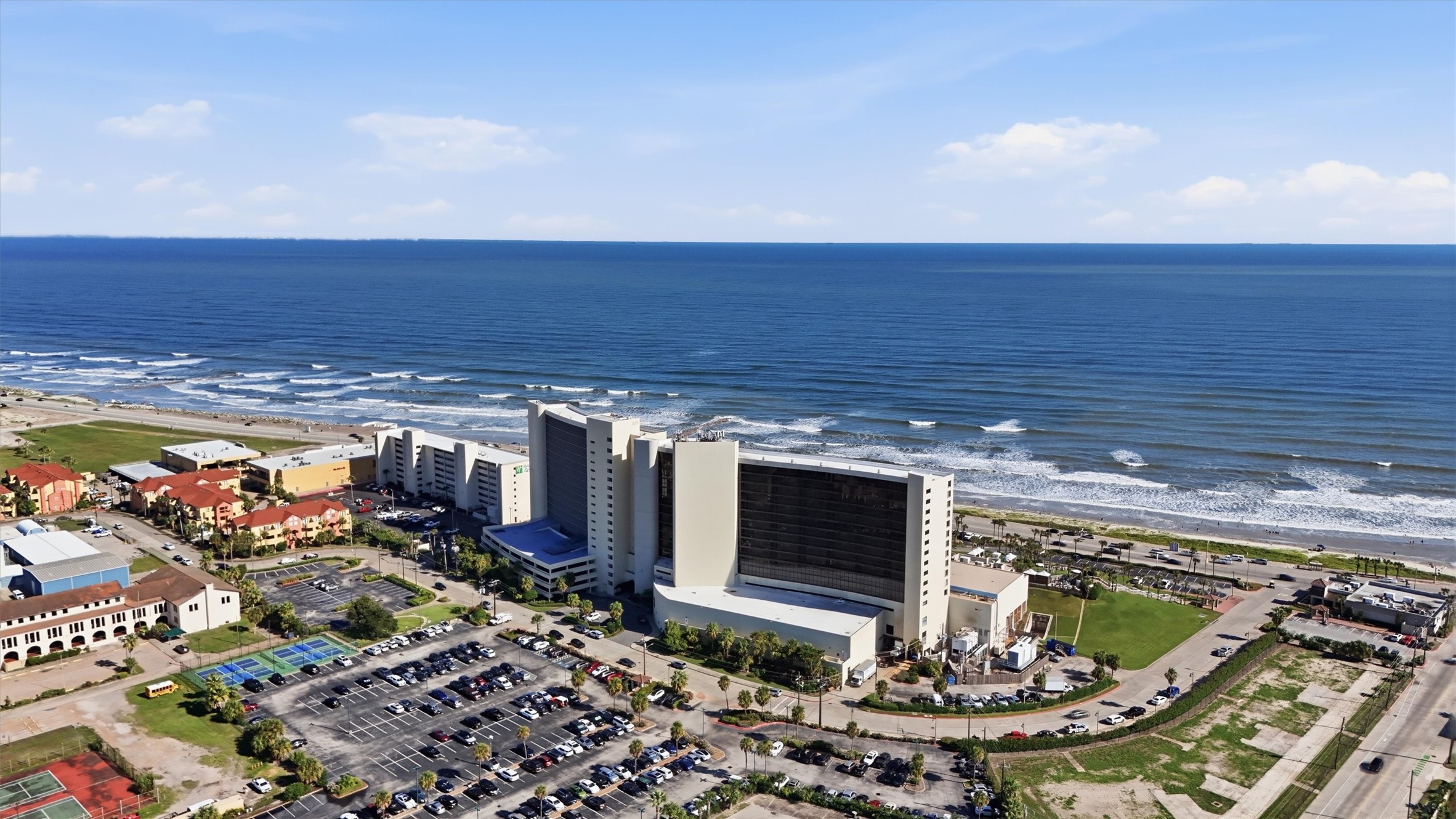 An expansive aerial view captures the San Luis, surrounding grounds, and the beach just across the Seawall.