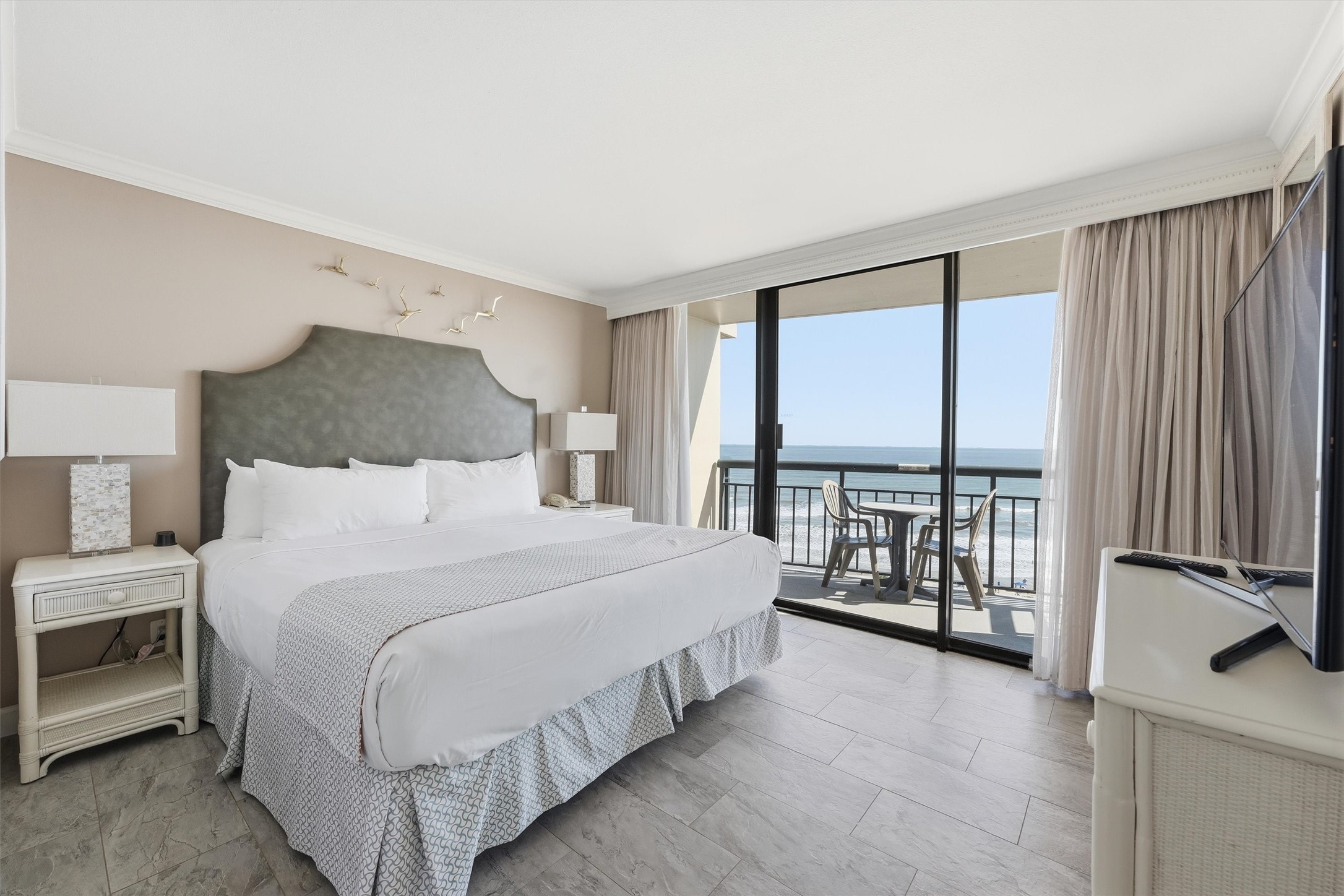 Rest and recharge in a light-filled bedroom with Gulf views and direct access to a balcony.