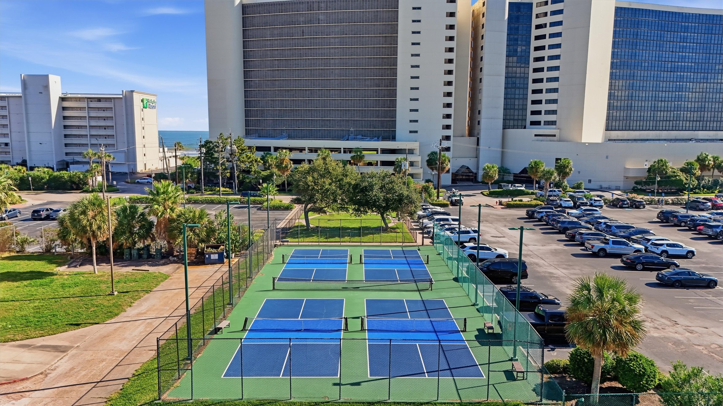 On-site tennis courts offer a scenic setting for a friendly match beneath the coastal sky.