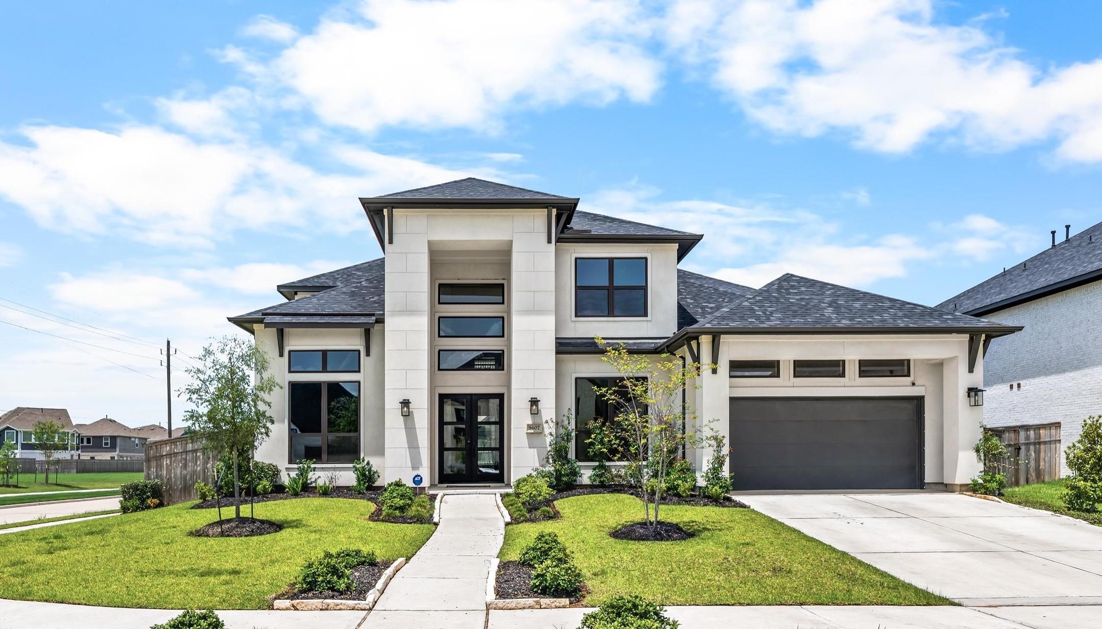 Modern two-story home with sleek design, large windows, and a well-manicured lawn on a spacious corner lot. Modern two-story home with sleek design, large windows, and a well-manicured lawn on a spacious corner lot.