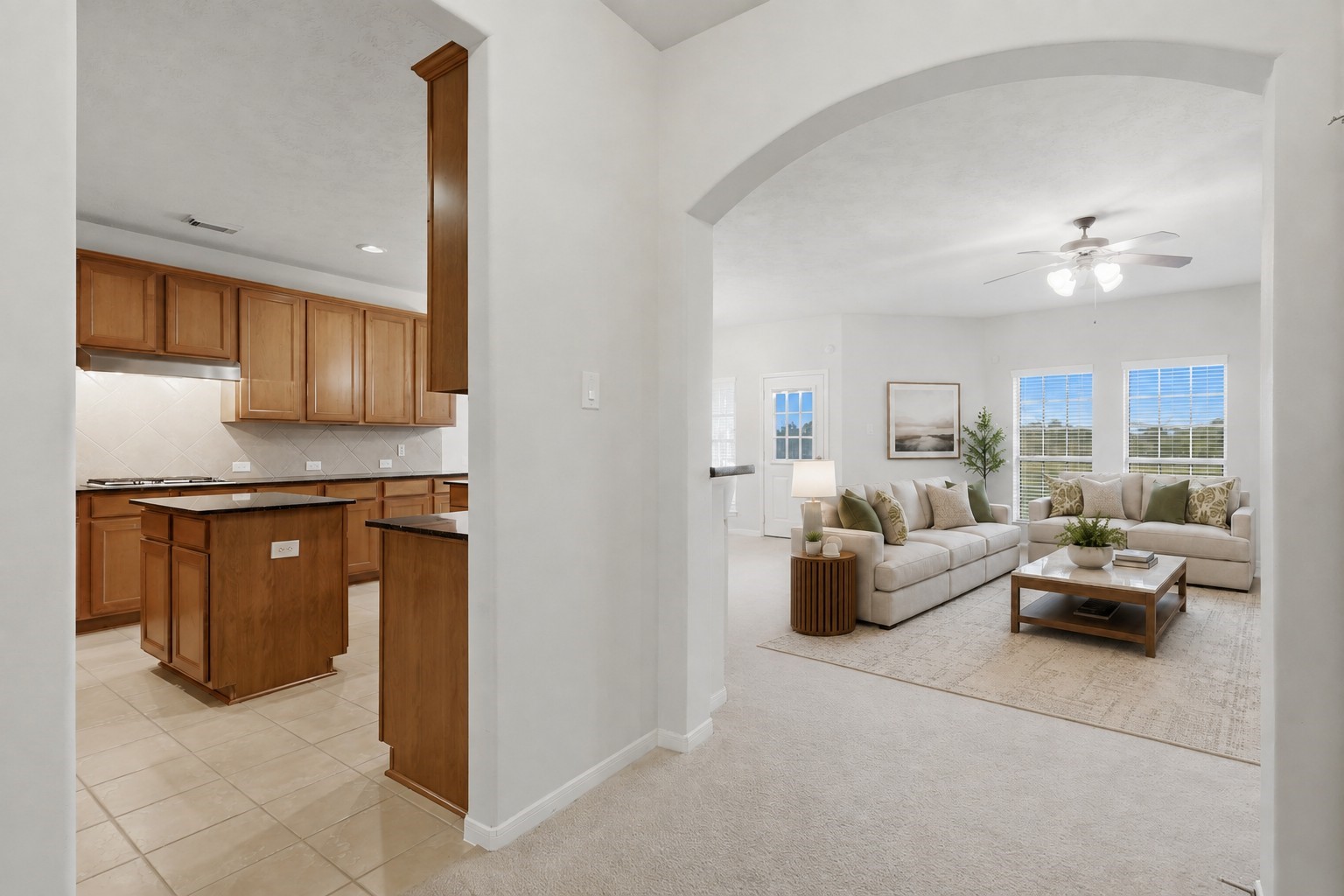 A wide arched opening creates an inviting connection between the kitchen and spacious family room.**Virtually staged