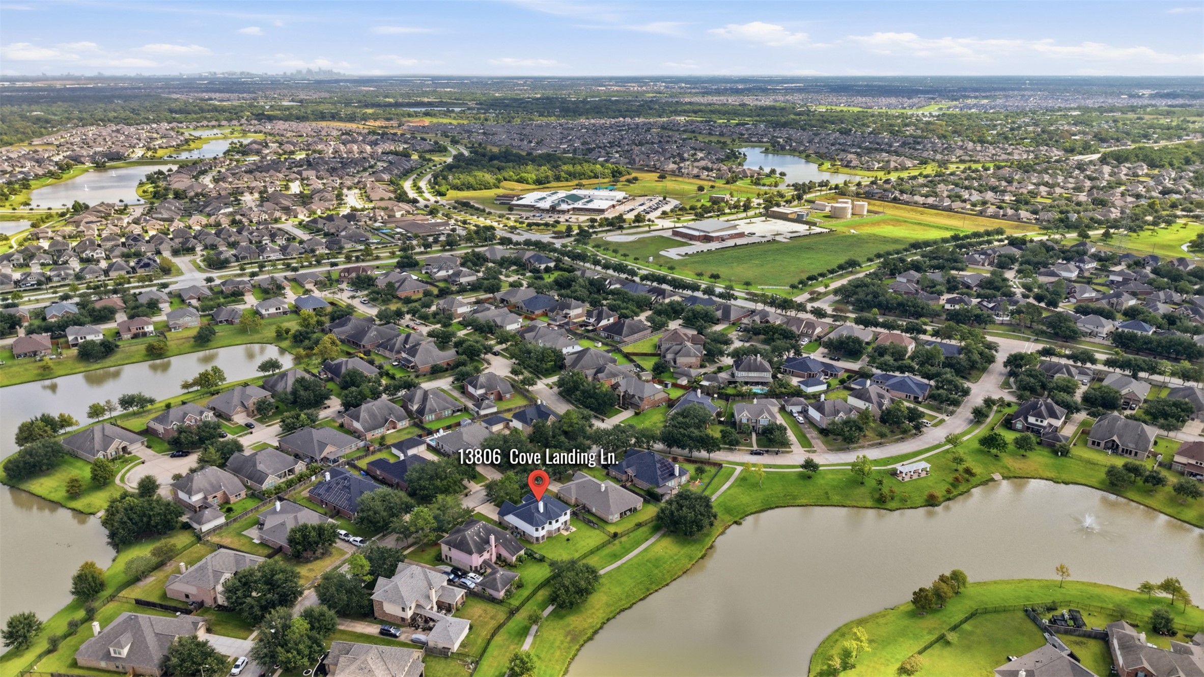 A broader aerial view highlights the homes convenient setting within a well-planned community surrounded by multiple lakes and green spaces.