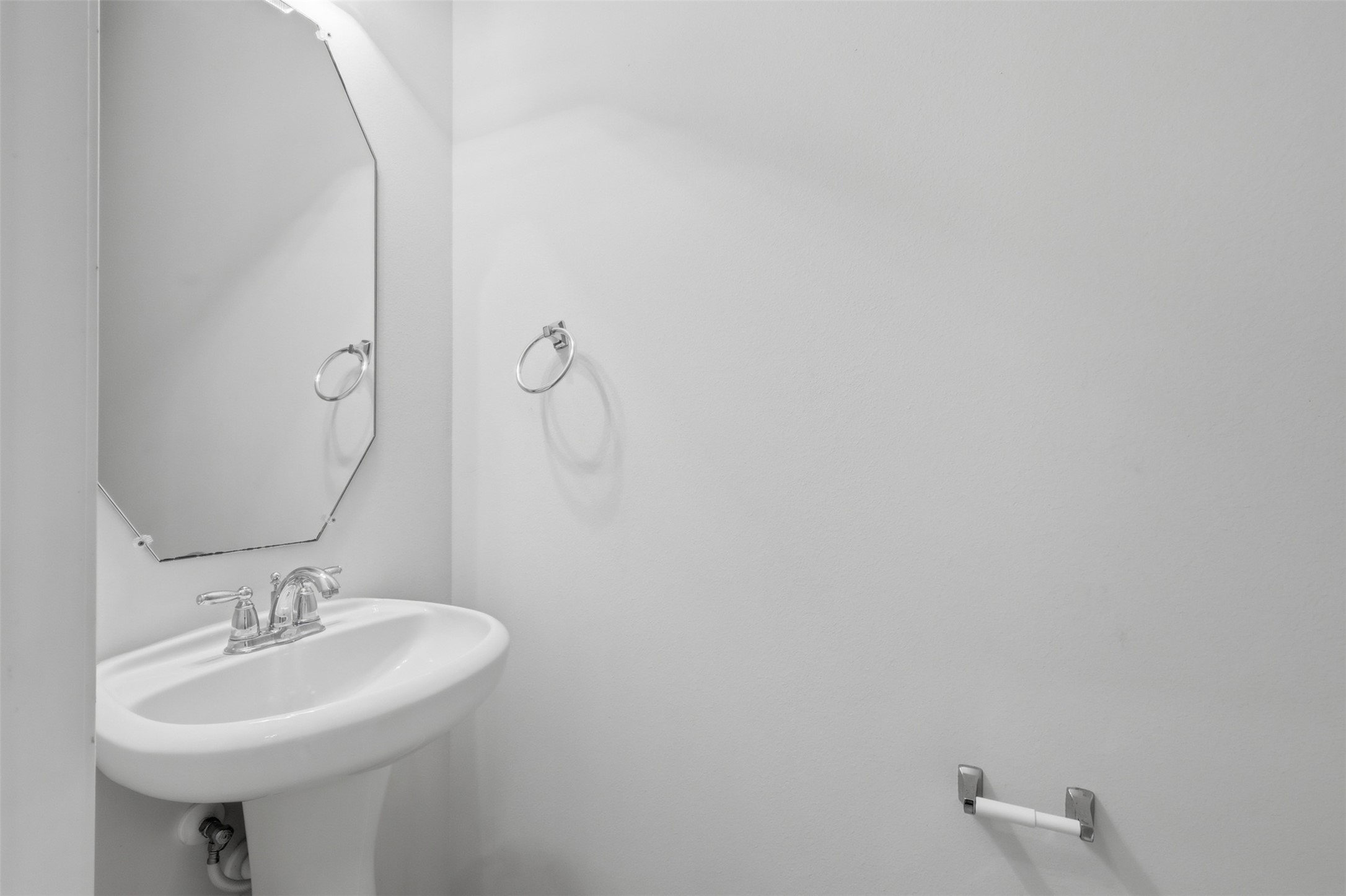 The convenient half bath features a pedestal sink and a clean, functional design.