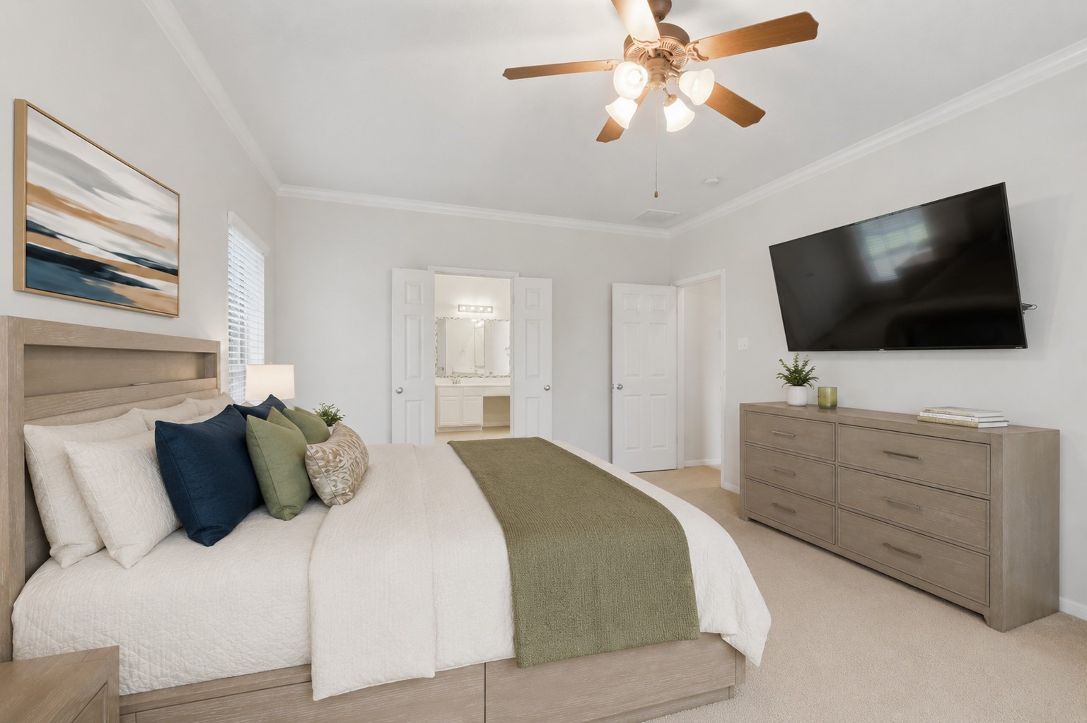 Another view of the primary suite highlights its generous proportions, crown molding, and convenient access to the en-suite bath.**Virtually staged