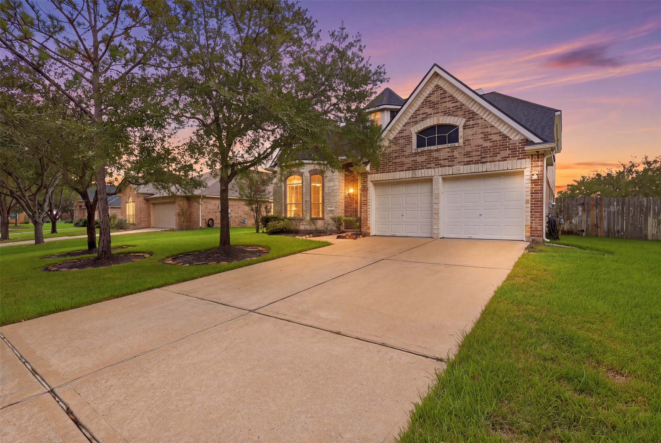 Twilight views highlight the homes warm exterior lighting, distinctive rooflines, and welcoming front elevation.