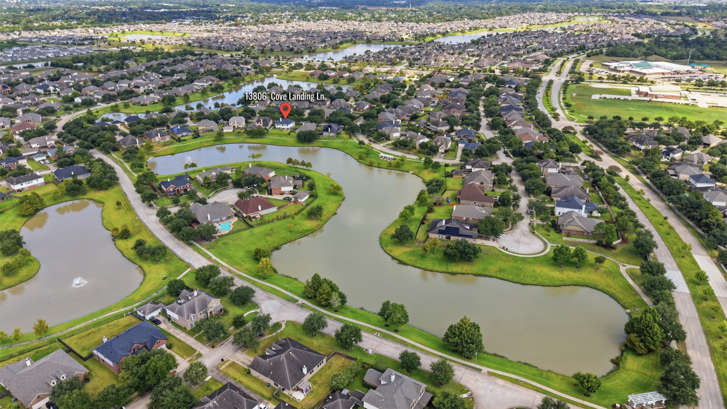 The aerial perspective showcases 13806 Cove Landing Lane within Savannah Coves established neighborhood of lakes and winding streets.