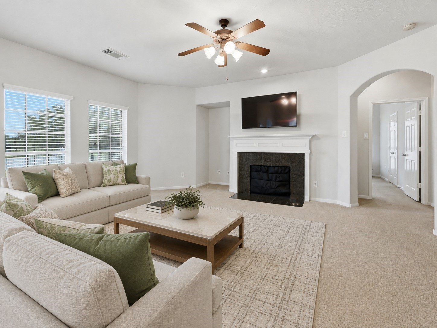 The family room is anchored by a classic fireplace and enhanced by large windows, generous proportions, and an arched hallway entrance.**Virtually staged