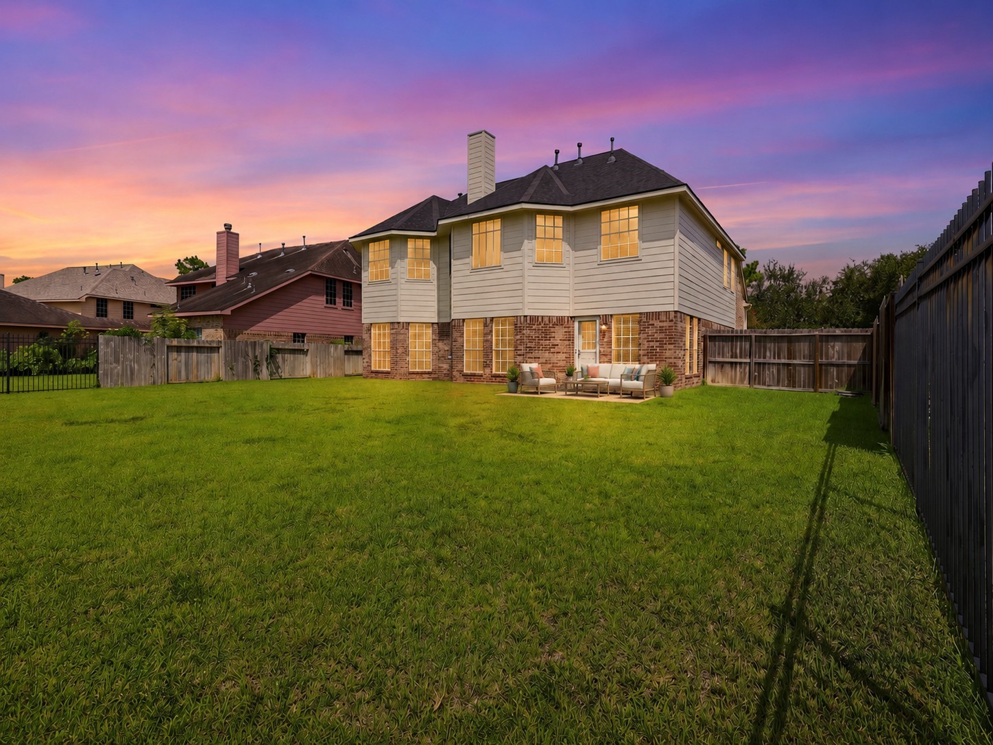 Twilight views highlight the homes rear elevation, expansive yard, and warm exterior lighting.**Virtually staged
