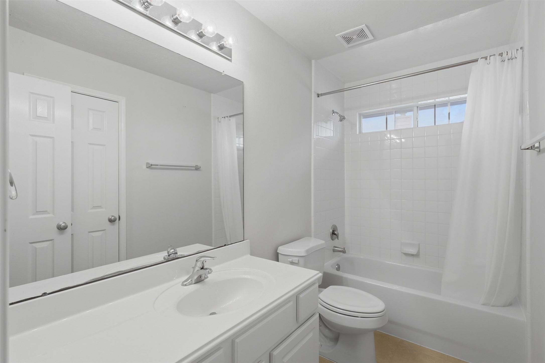 Another full bath offers a tub-and-shower combination, large vanity, and a bright, practical layout.