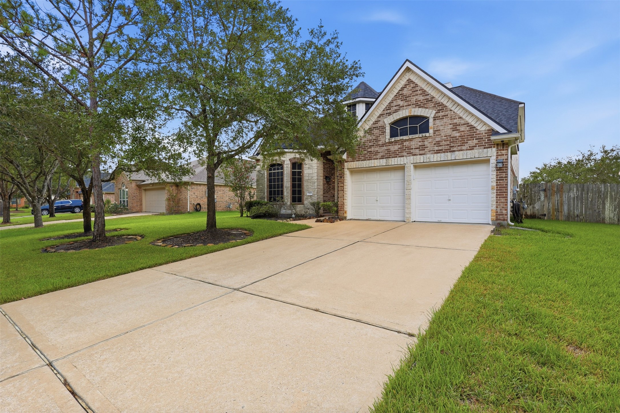 A spacious driveway, two-car garage, and well-maintained landscaping complement the homes attractive architectural design.