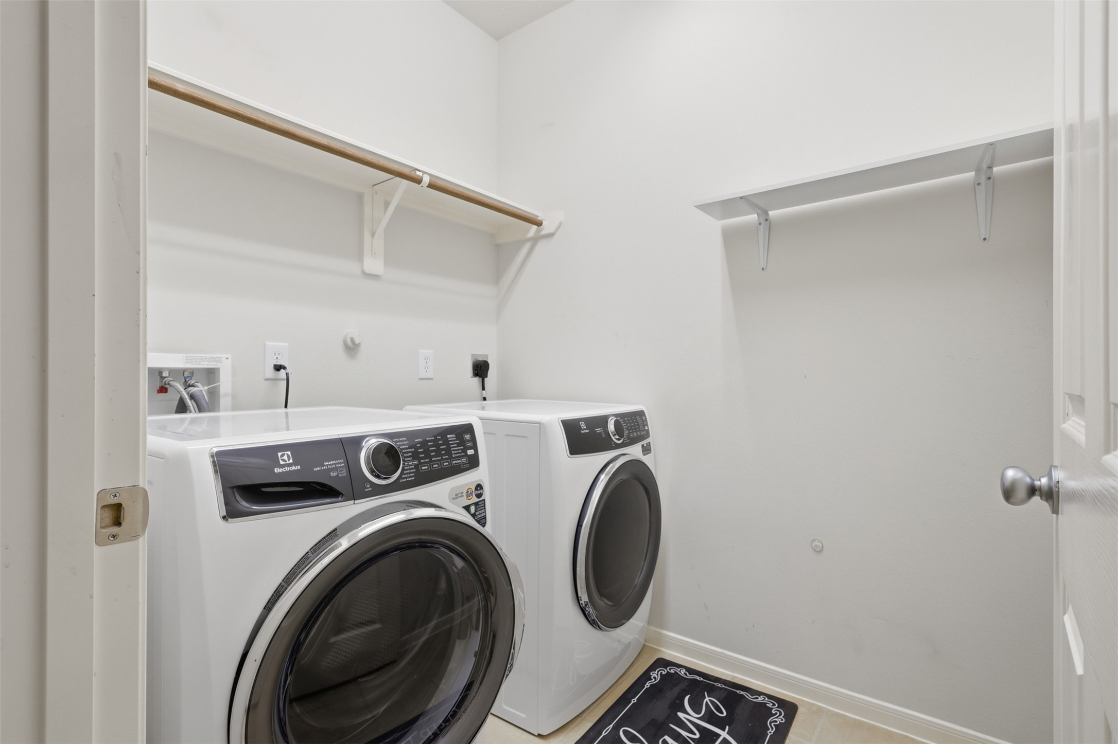 The dedicated laundry room offers built-in shelving, hanging space, and room for full-size appliances.