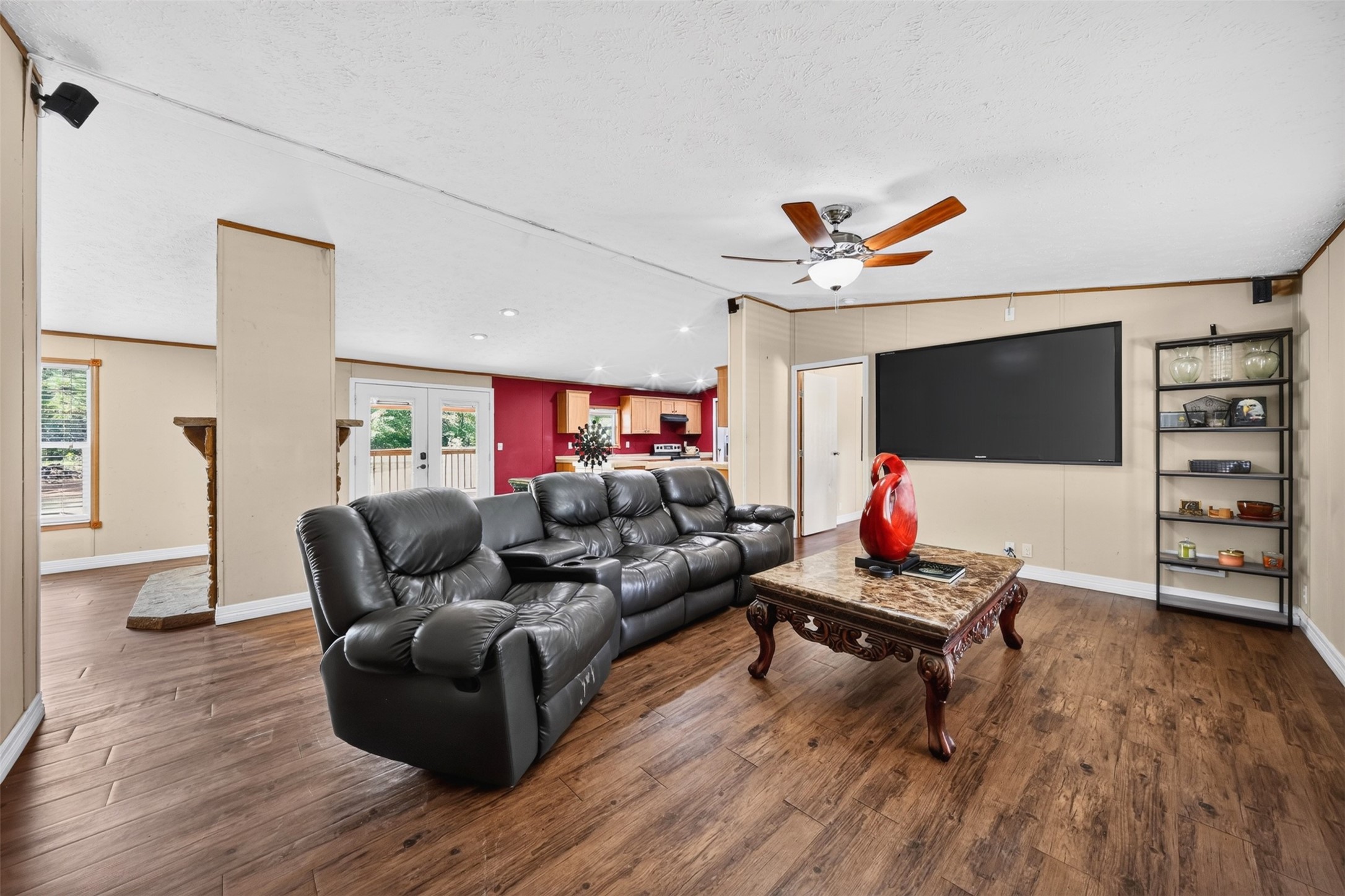 Bright living space with wood-look flooring, ceiling fan, and natural light.