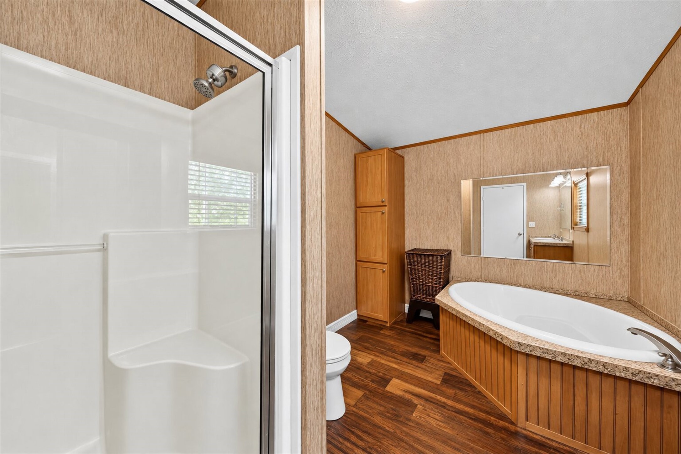 Full bathroom featuring a tub/shower combination, vanity, and warm wood cabinetry.