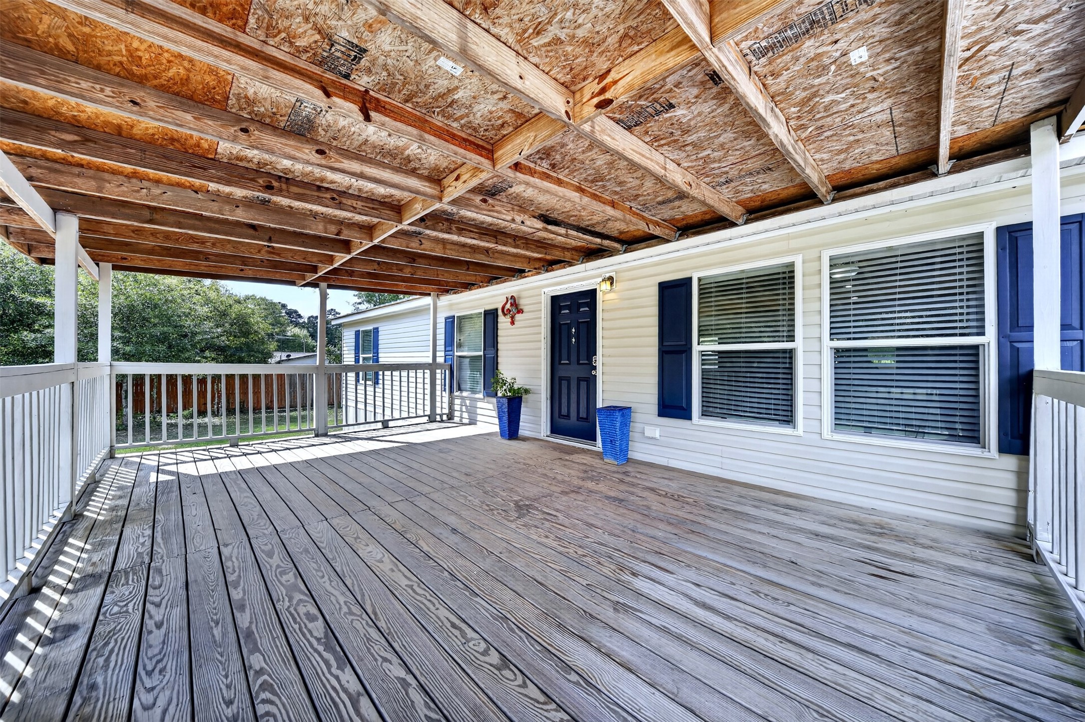 Spacious covered deck provides a shaded outdoor area overlooking the property.