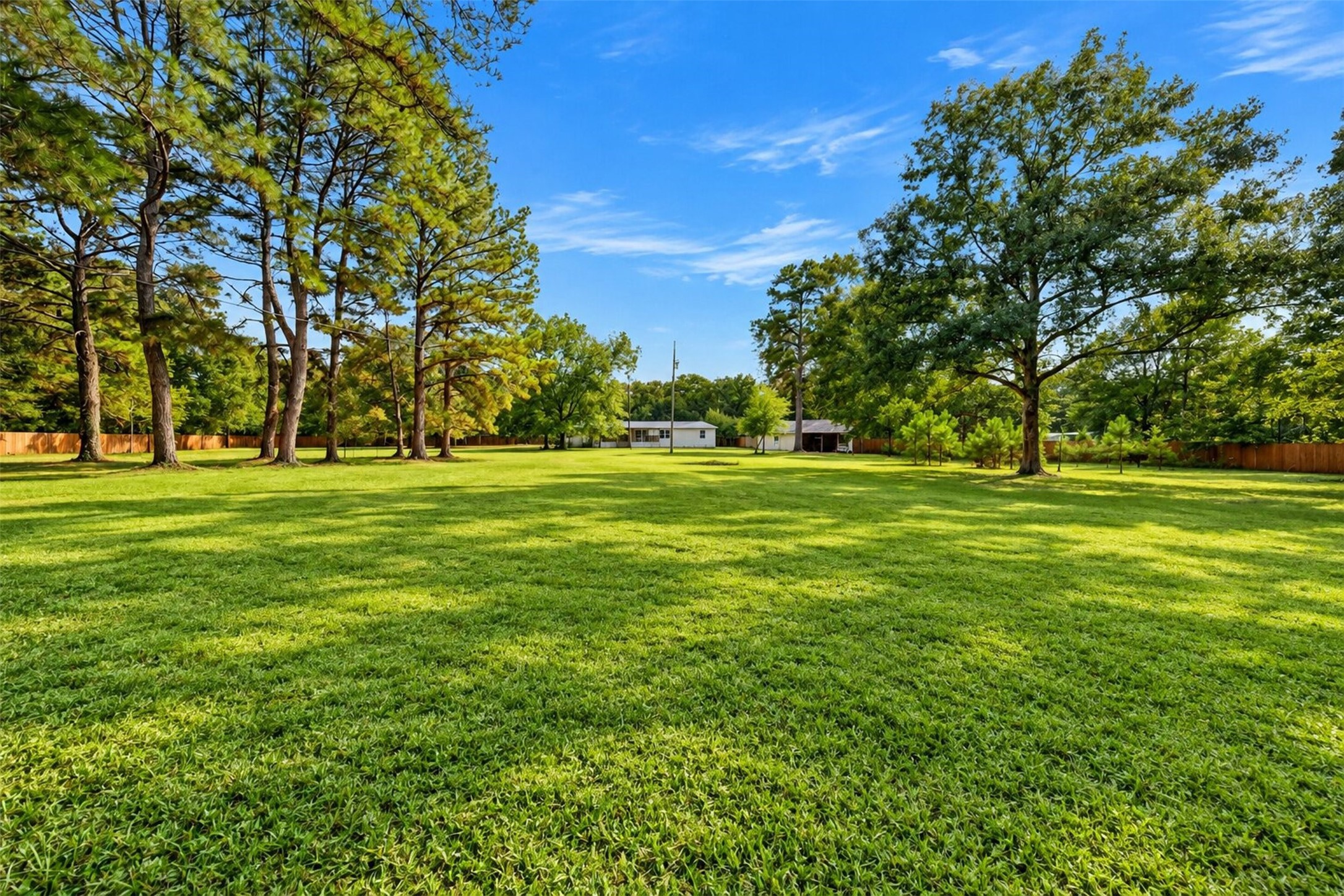 Expansive yard surrounded by mature trees with plenty of space to enjoy the outdoors.