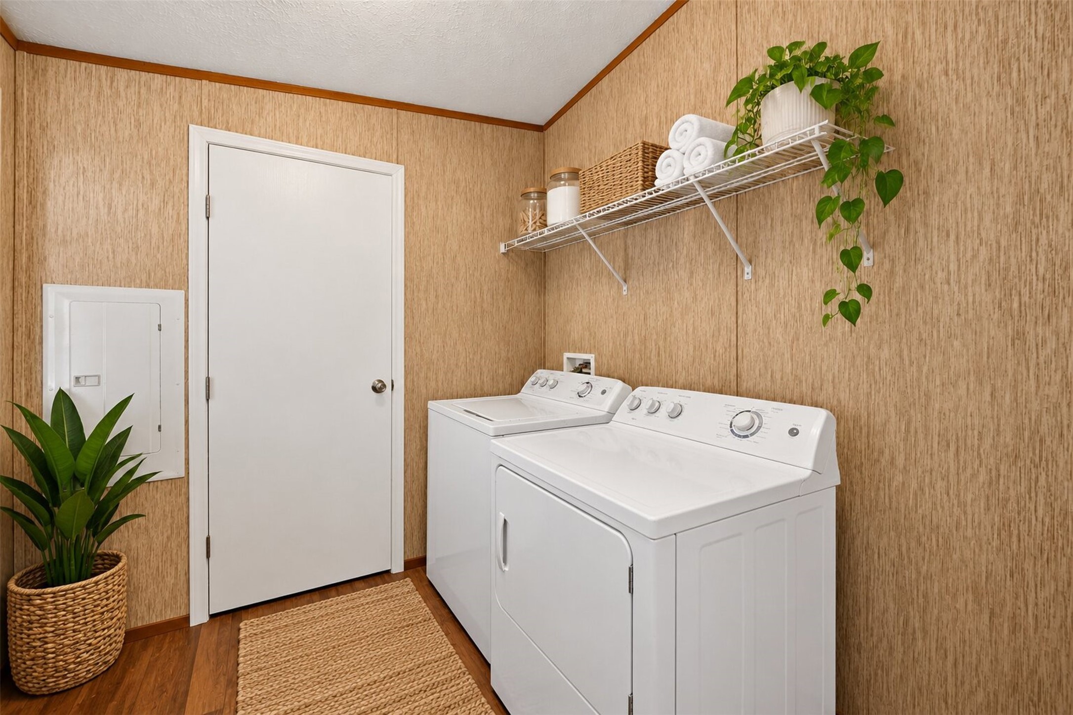 Virtually staged utility room with washer and dryer connections and additional storage space.