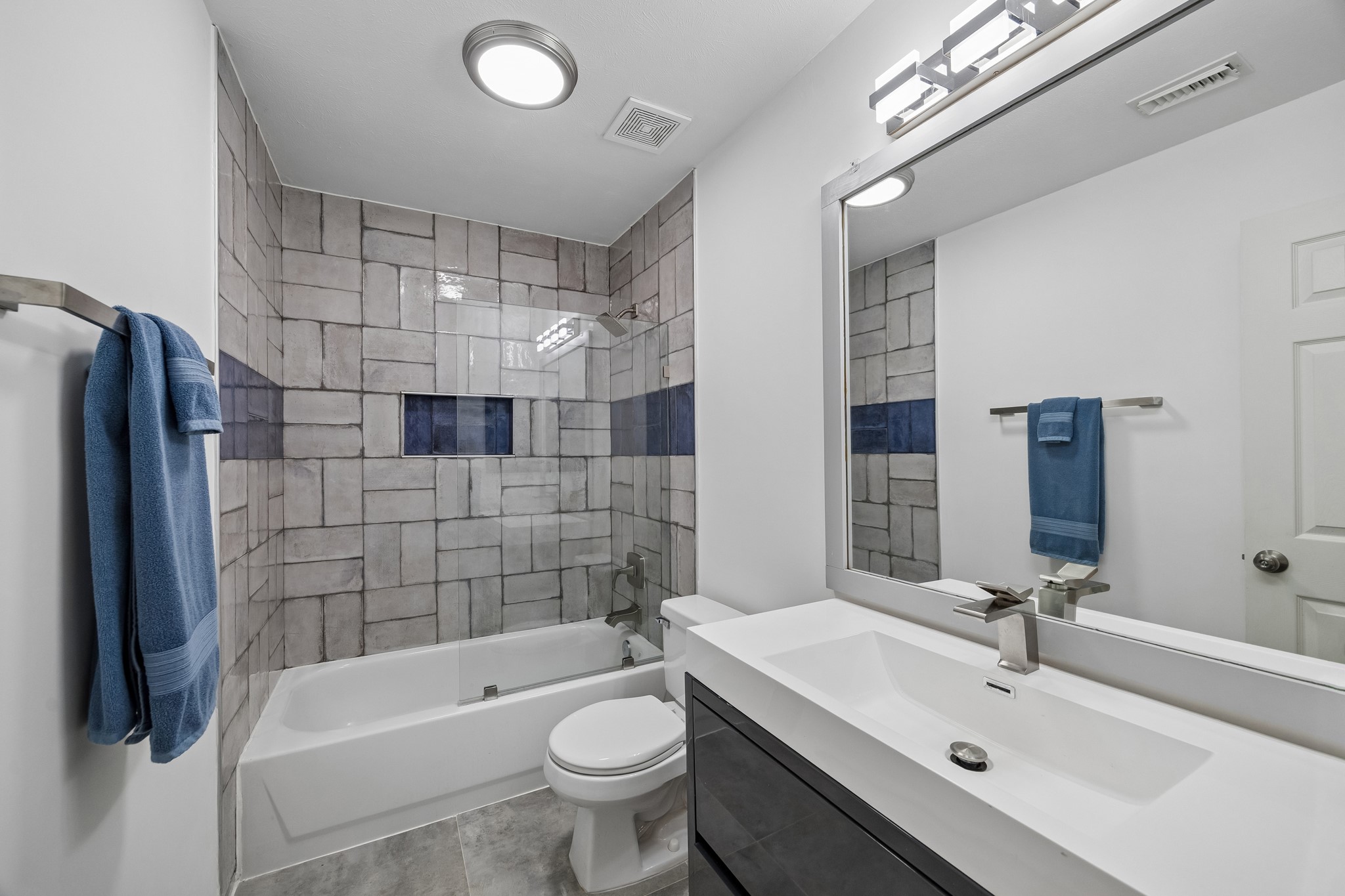 Upstairs hall bathroom with tile surround tub/shower and granite countertop on the vanity.