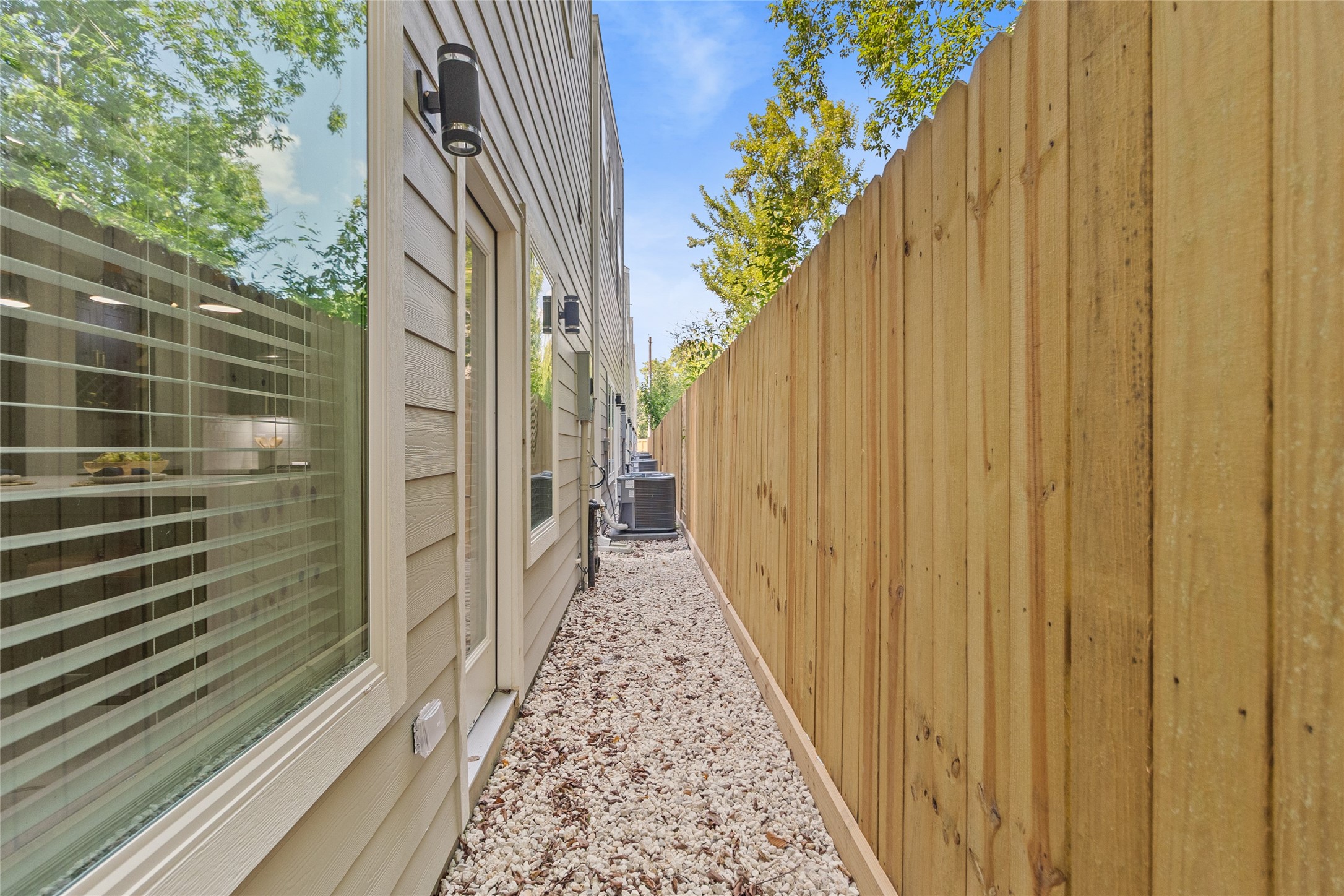 The backyard feels like your own hidden escape  neat, secure, and freshly fenced. Its where youll keep the AC units humming along, set up storage if needed, or even create a low-maintenance side garden with potted plants that catch the afternoon sun.