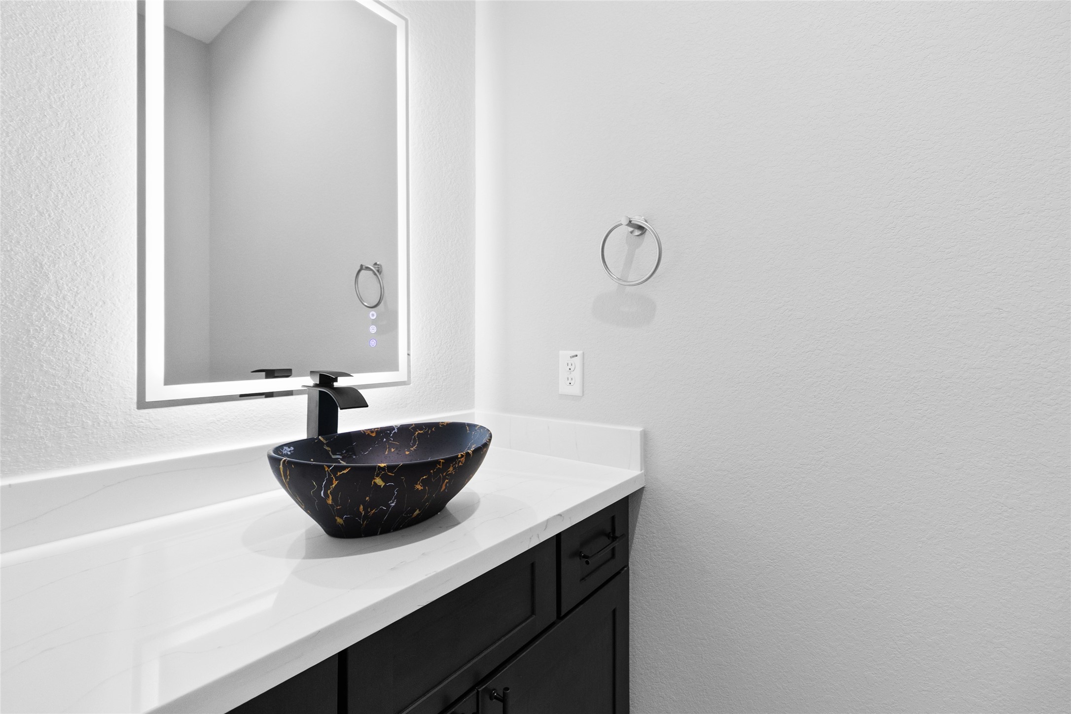 Your powder bath feels like a designers touchevery detail, from the glowing mirror to the deep blue vessel sink, makes even quick stops feel luxurious.