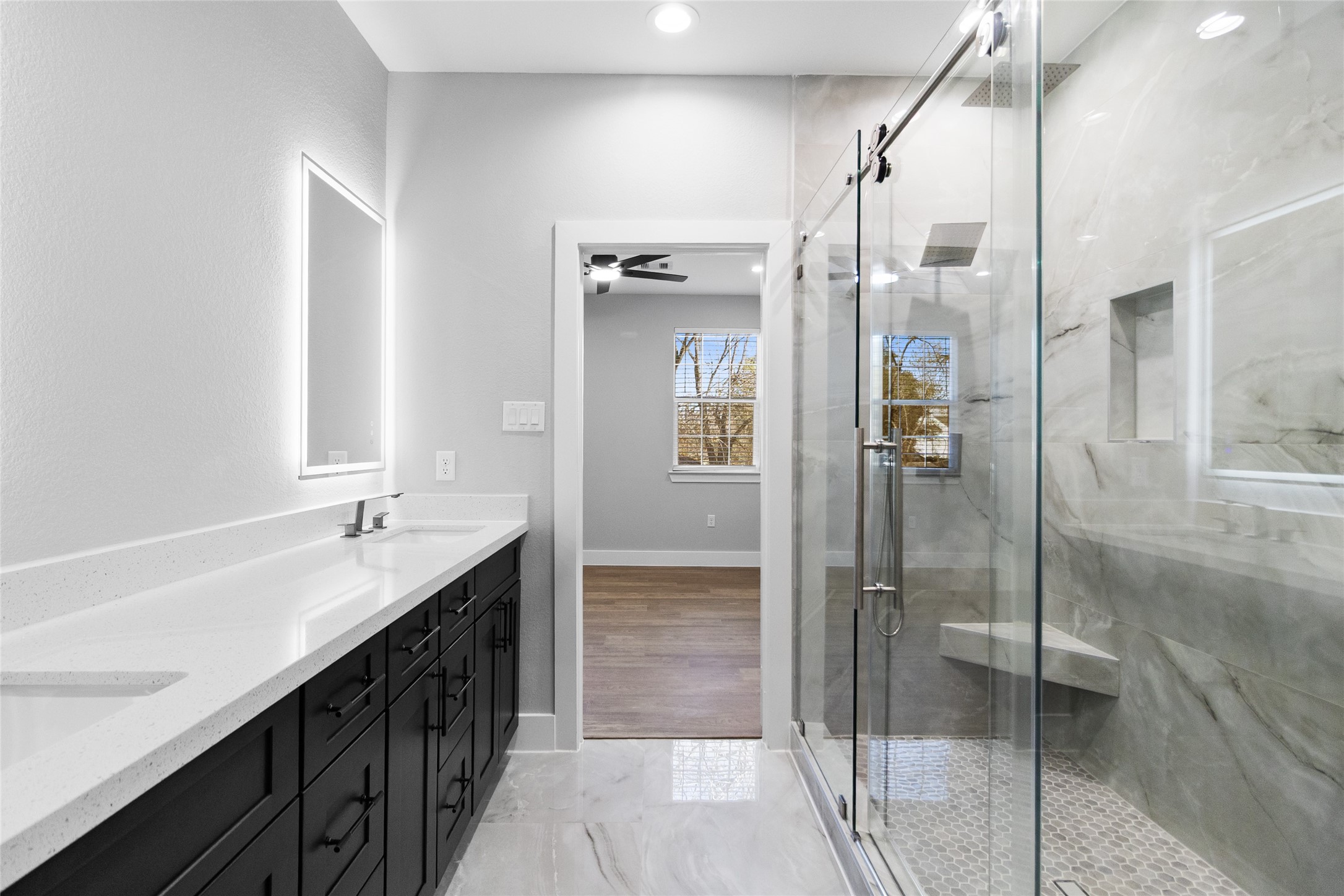 The walk-in shower, framed in glass and marble-style tile, gives you a daily dose of luxury while leading straight into your roomy closet.