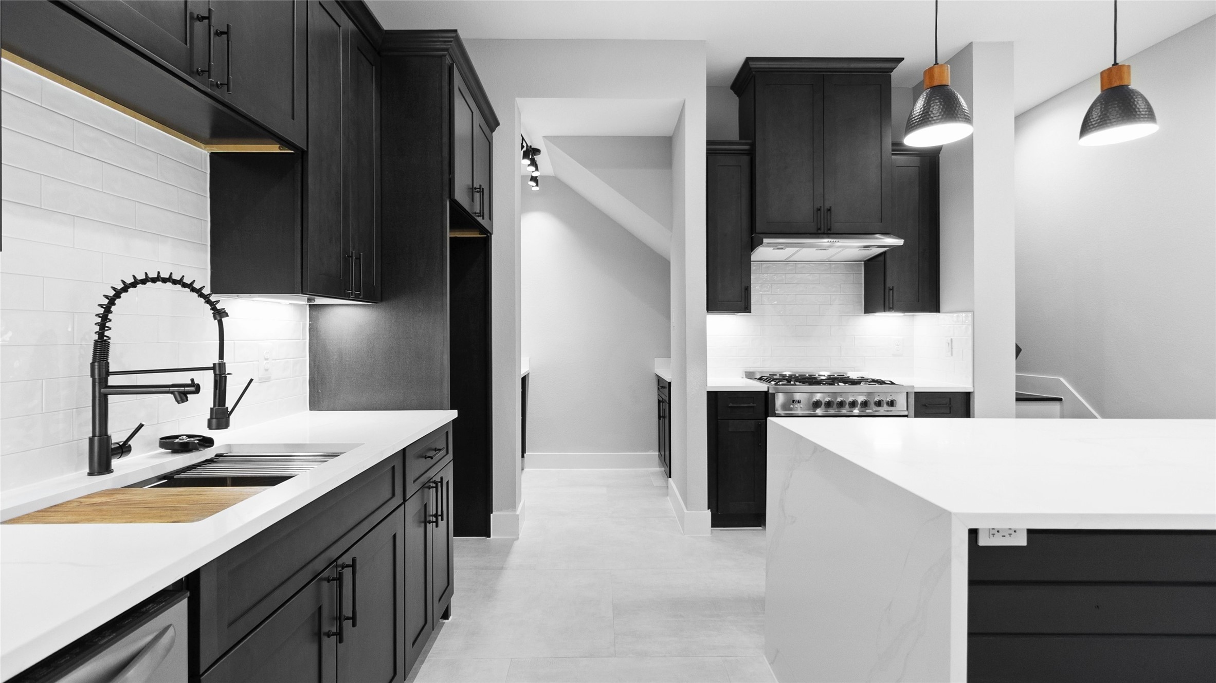 Cooking feels effortless with the sleek navy cabinetry, gold fixtures, and plenty of counter space to spread out and create.