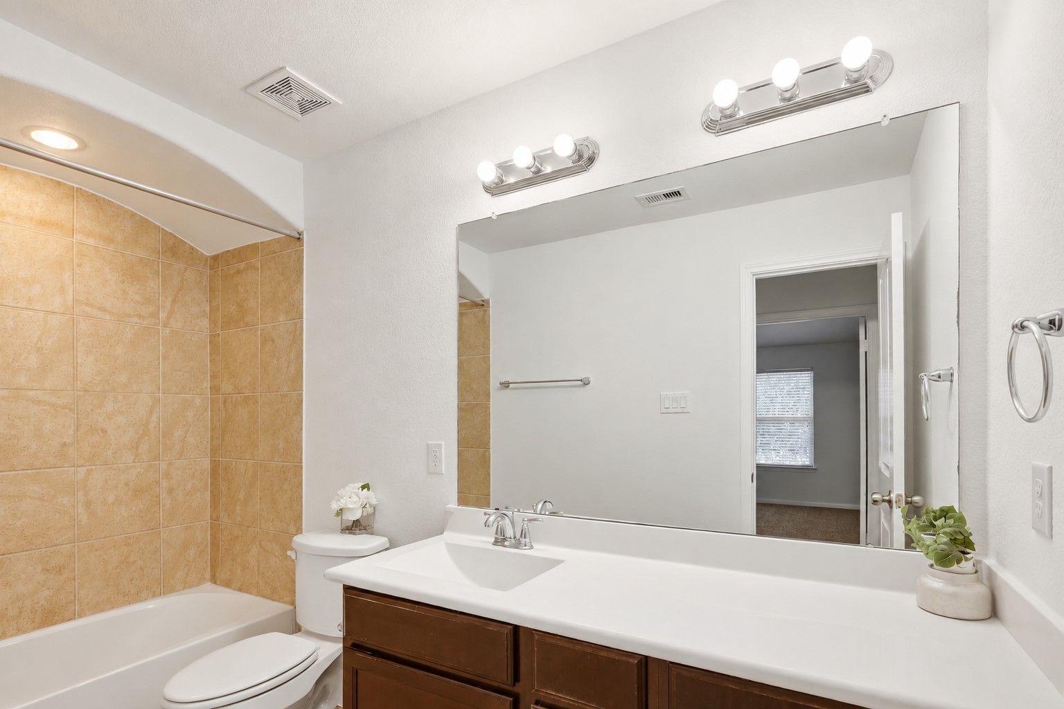 Bright & Beautiful Secondary Bath! This well-appointed bath features a spacious vanity with generous counter space, a large mirror, and warm tile accents. The clean, neutral finishes create a fresh and welcoming space that is convenient for family members and guests alike.