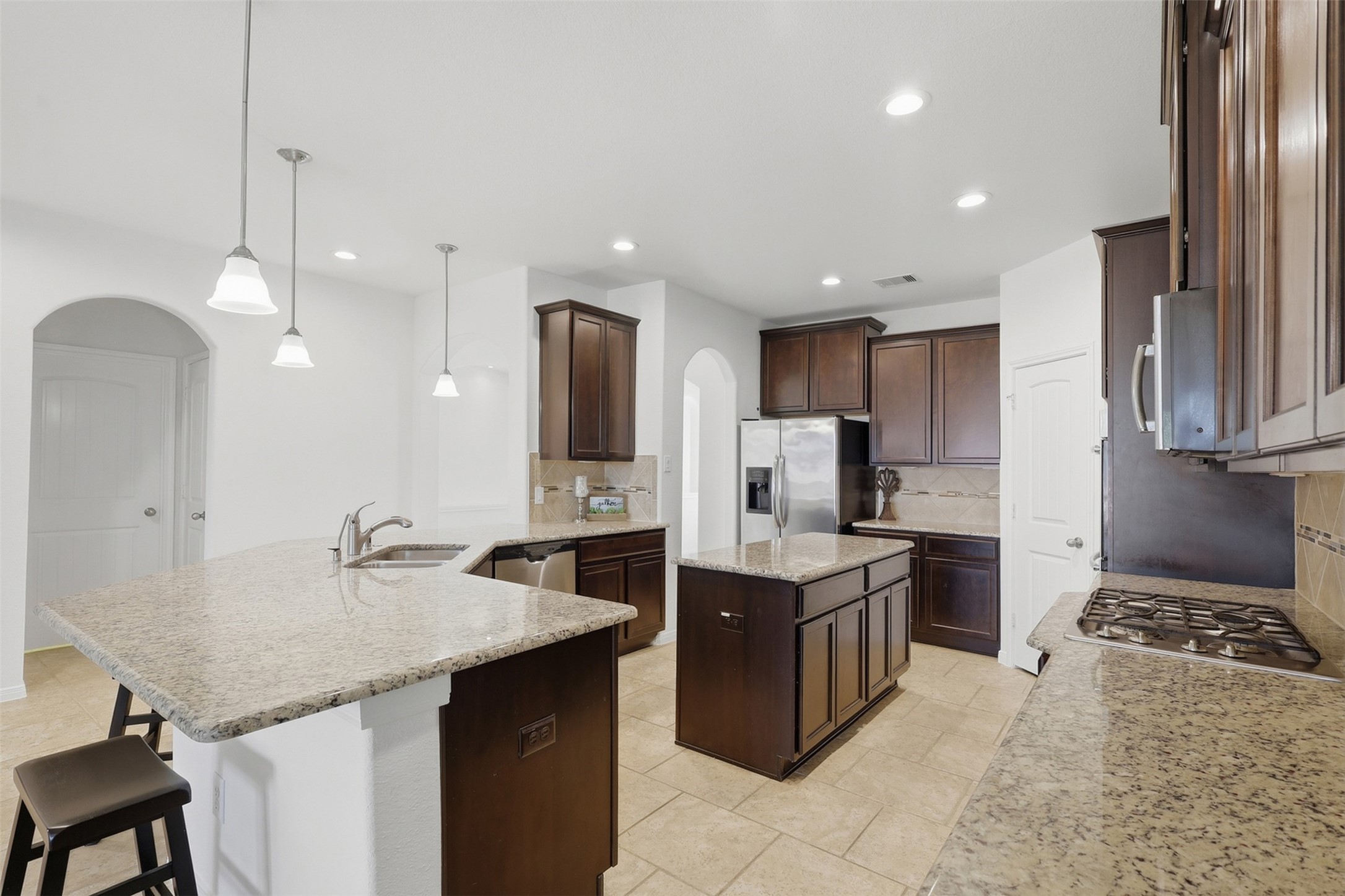 The Kitchen Truly Becomes the Gathering Place! From this view, you can appreciate the generous counter space, large island, rich cabinetry, stainless steel appliances, and bright open layout. The kitchen flows naturally toward the dining and family areas, giving everyone plenty of room to cook, gather, and enjoy time together.