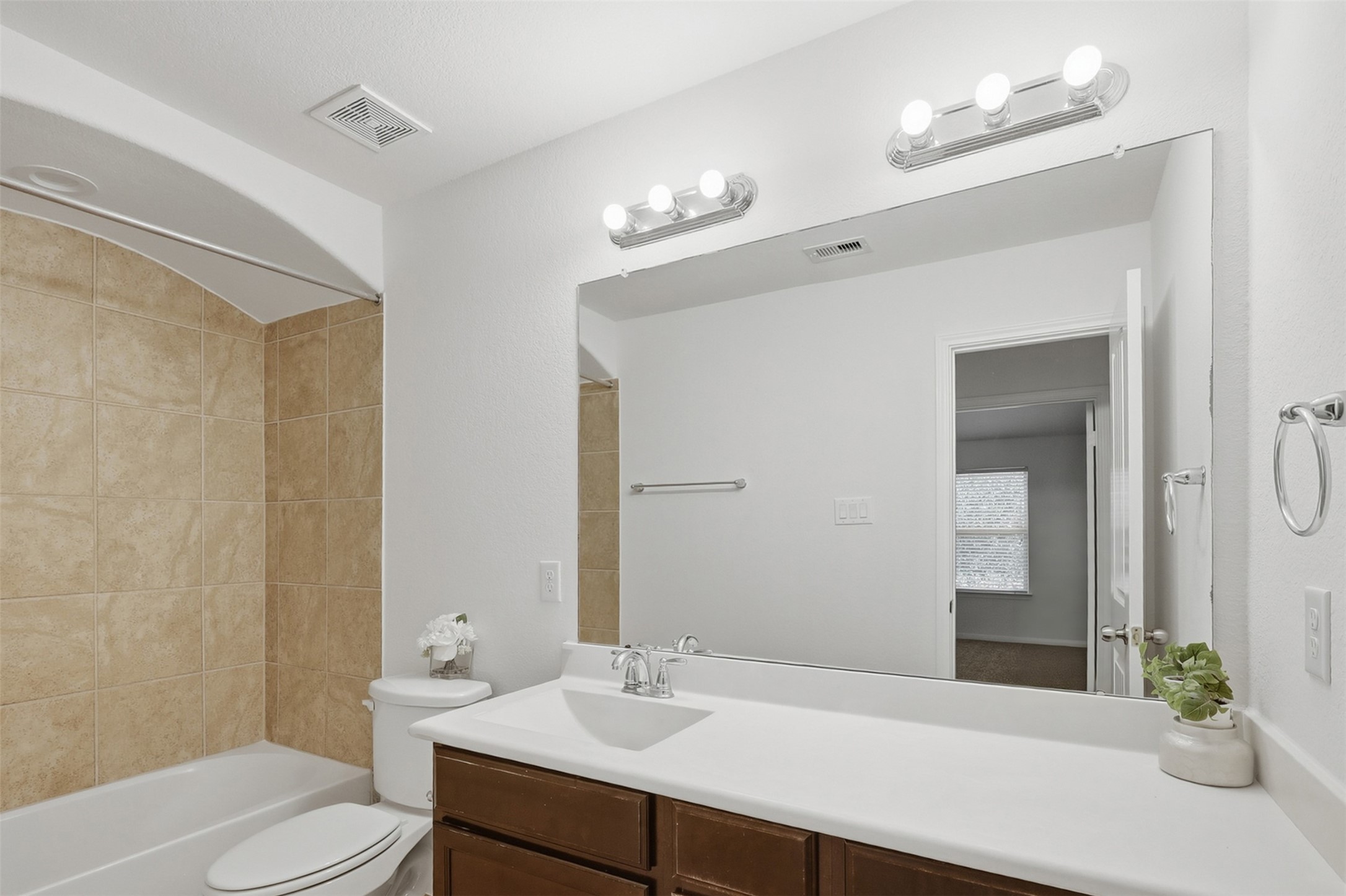 Clean, Bright & Nicely Appointed! This secondary bath features a generous vanity with plenty of counter space, a large mirror, and attractive lighting. Warm cabinetry and neutral finishes give the room a fresh, timeless appearance that is both practical and inviting.