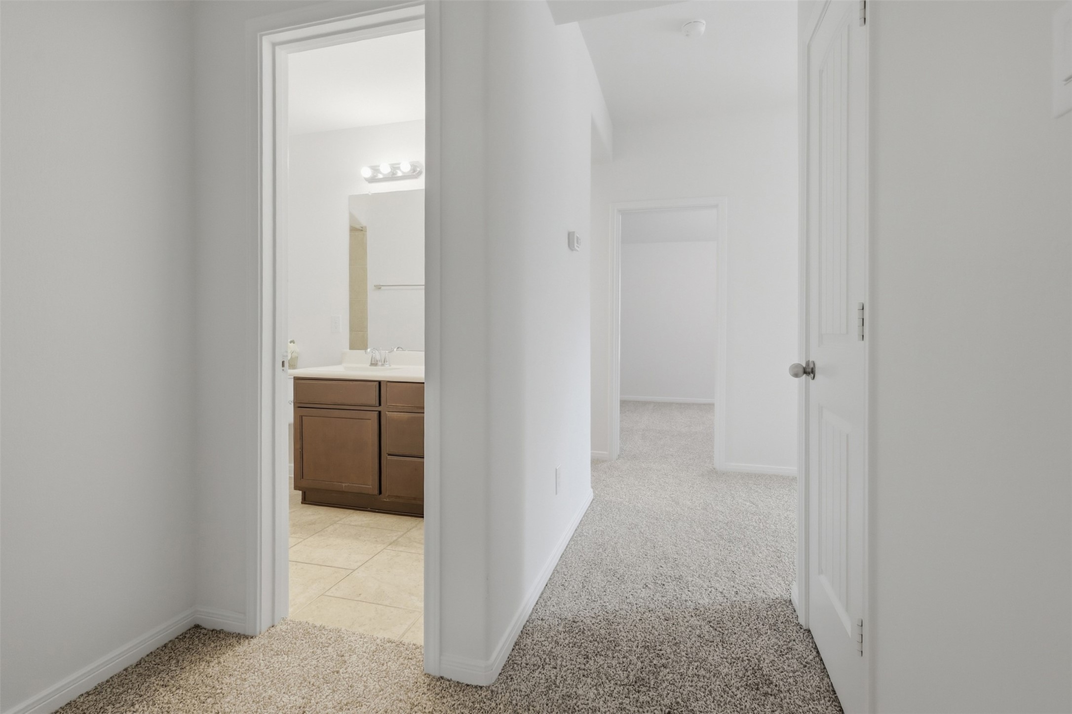 Easy Access Throughout the Upstairs! This bright hallway provides a comfortable transition between the bedrooms and bath, with plush carpeting and clean neutral finishes. The open layout makes it easy to move from one room to another while maintaining the home's bright and welcoming feel.