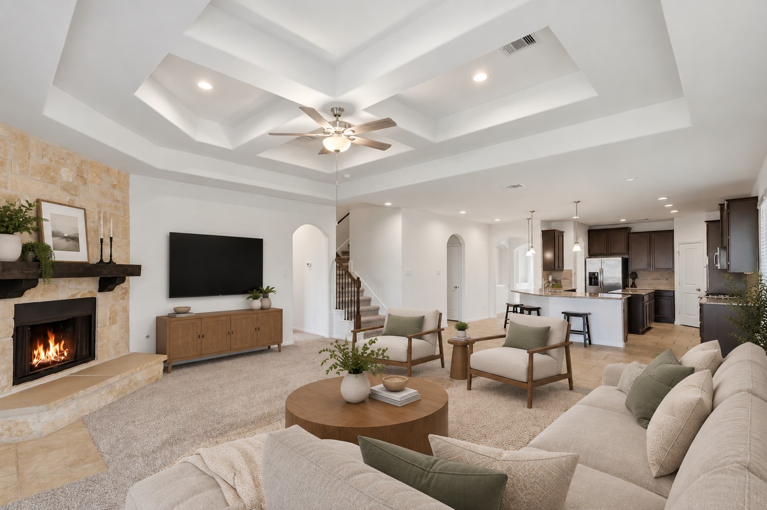 A Wonderful Space to Gather, Relax & Entertain! This spacious family room showcases soaring custom ceilings with beautiful recessed detailing, a ceiling fan, and a stunning stone fireplace that creates a warm focal point. The open view toward the kitchen makes it easy to stay connected while cooking, dining, or relaxing. A wall of windows fills the room with natural light and looks out toward the private backyard. *Photo is virtually staged*