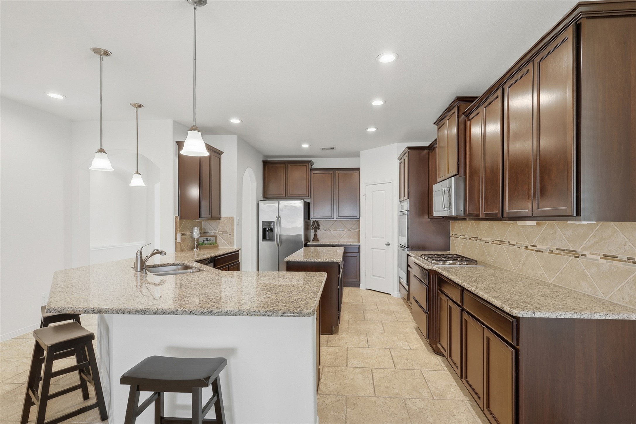 Beautiful Kitchen with an Open, Welcoming Design! This fabulous kitchen offers abundant custom cabinetry, granite countertops, a large center island, breakfast bar seating, stainless steel appliances, and beautiful pendant lighting. The open layout keeps the kitchen connected to the dining and living areasperfect for busy family life and entertaining!