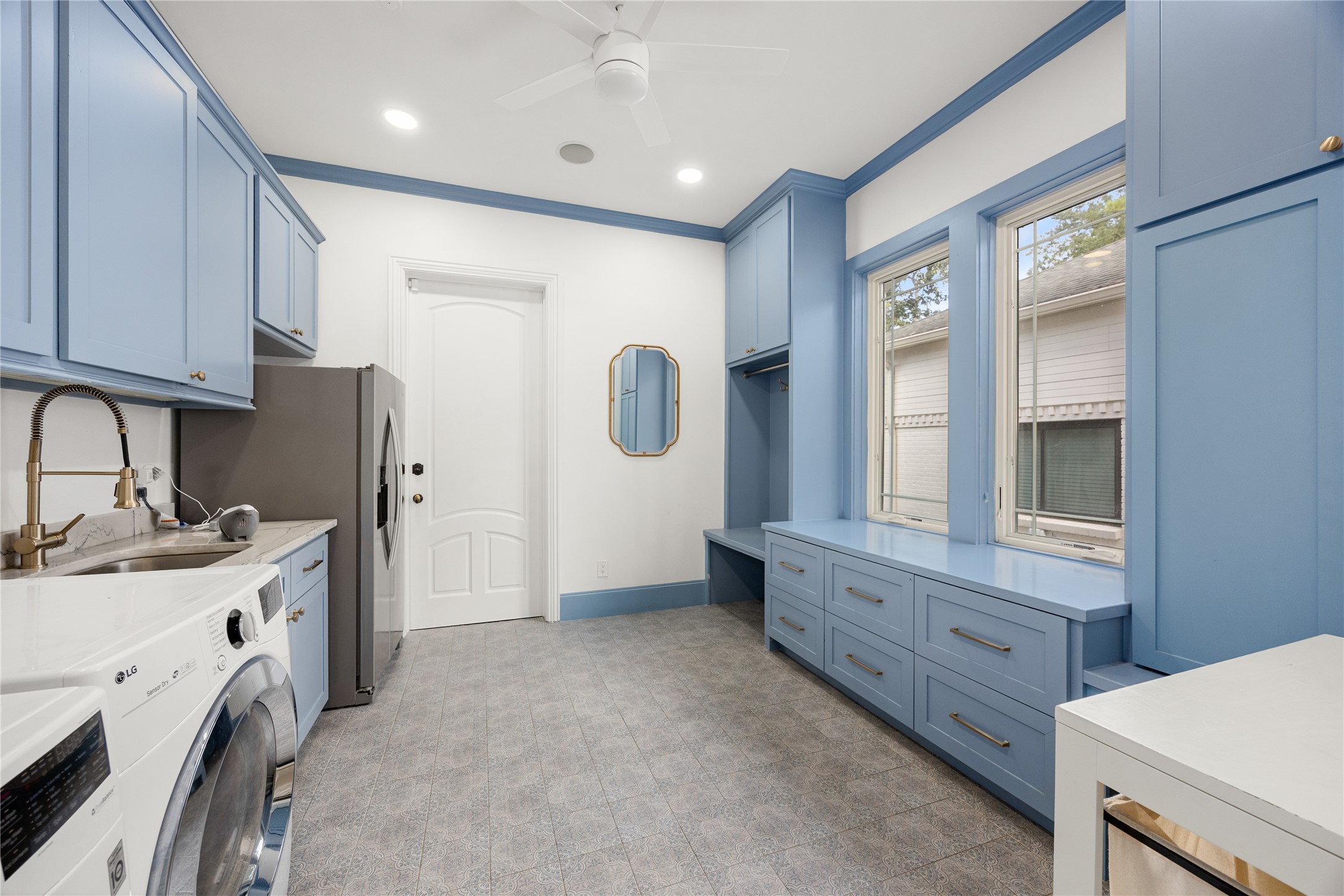 The huge laundry room has tons of storage and built ins, a sink and room for refrigerator.