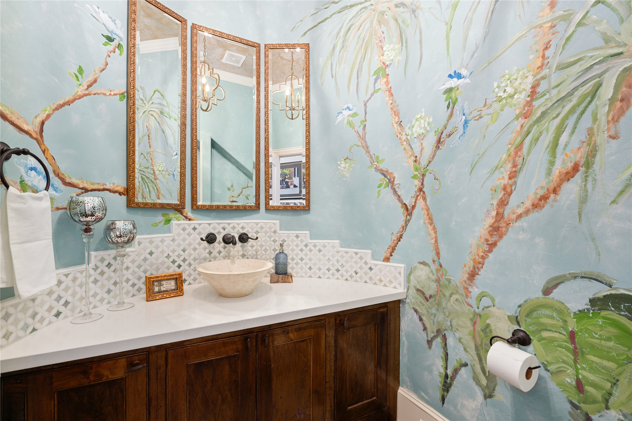 Half-bath under the stairs has a beautiful painted mural.