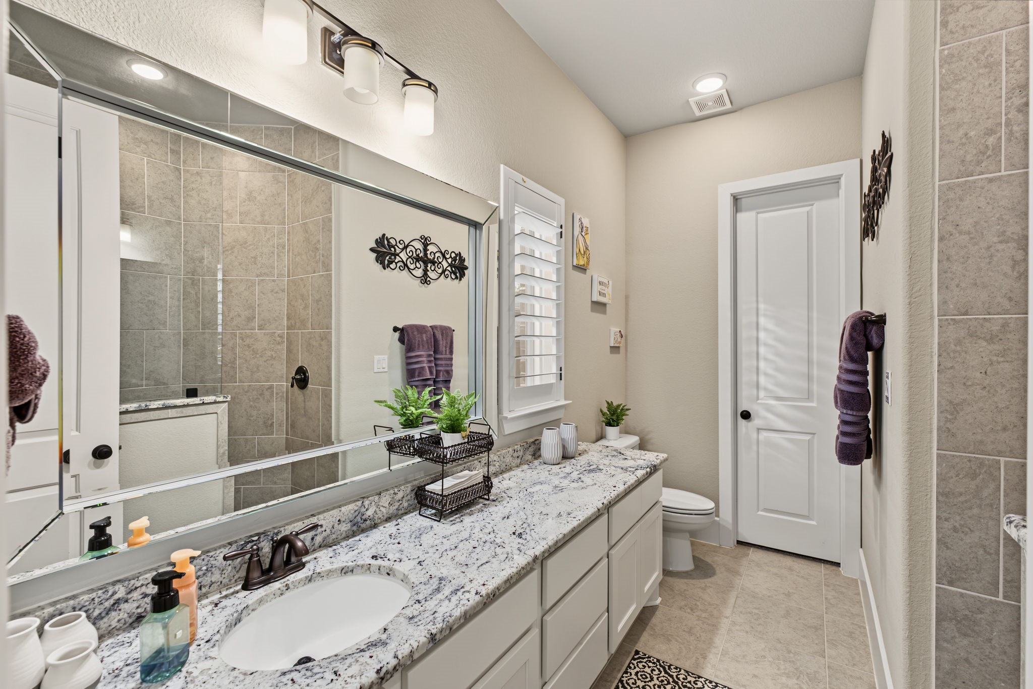 Private Downstairs Secondary Suite! Spacious secondary bedroom featuring its own en-suite bathroom with a granite vanity, beautiful tilework, and a walk-in showerperfect for guests or multigenerational living!