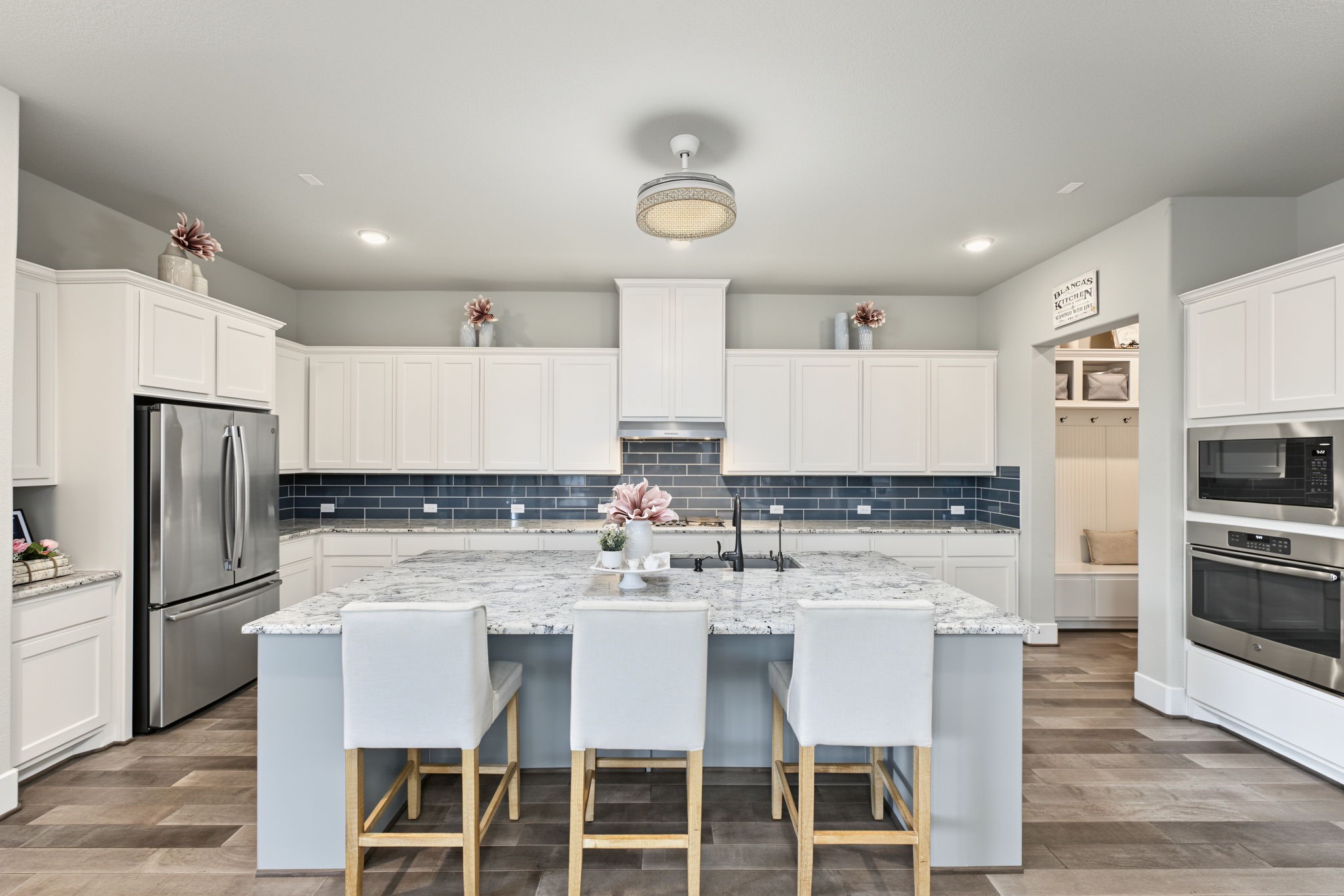 Gorgeous Gourmet Kitchen! Featuring an oversized island, beautiful granite countertops, white cabinetry, and stylish contrasting backsplash.