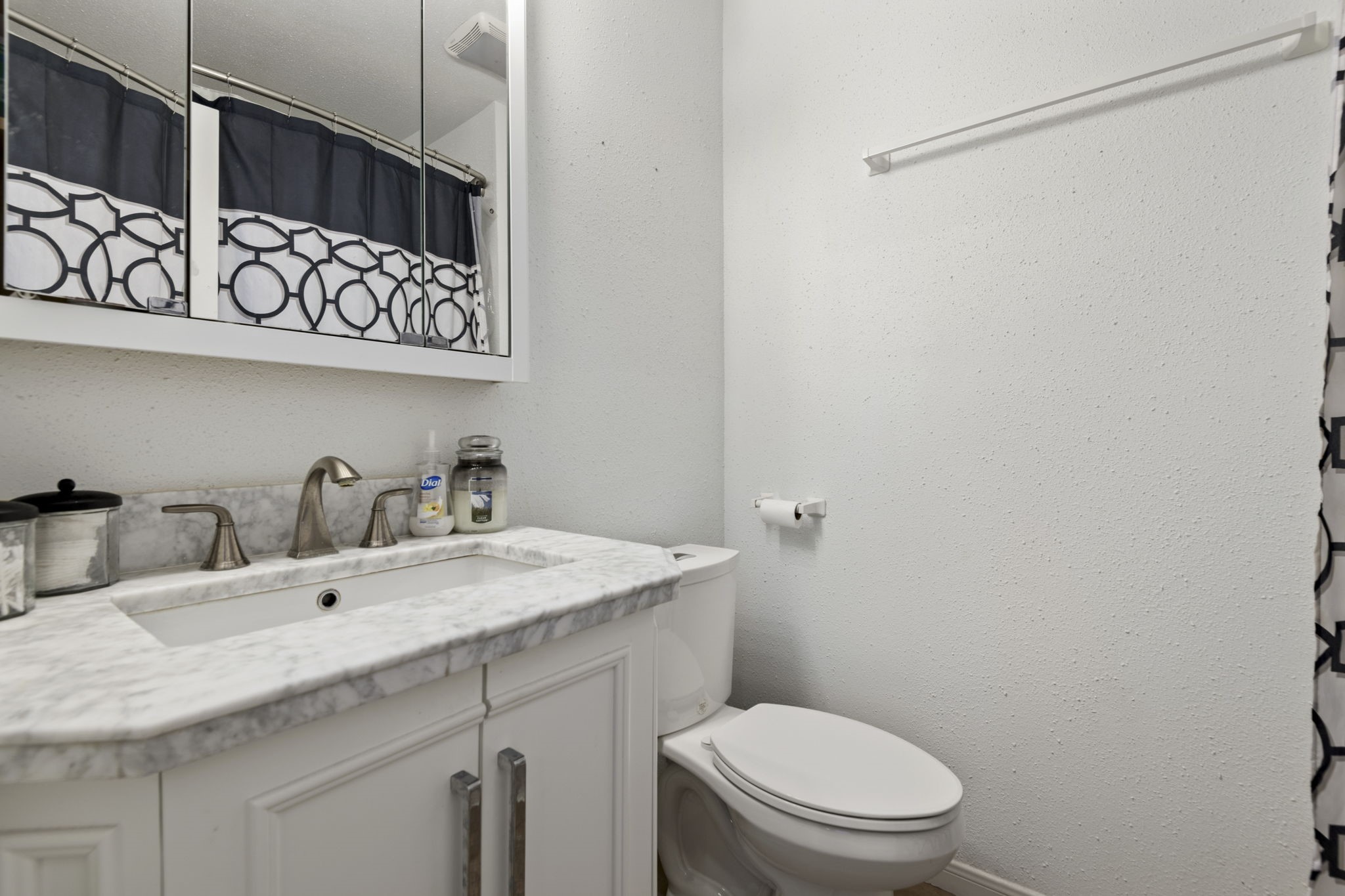 The ensuite bathroom attached to bedroom 1 has a shower/tub combo and charming vanity.