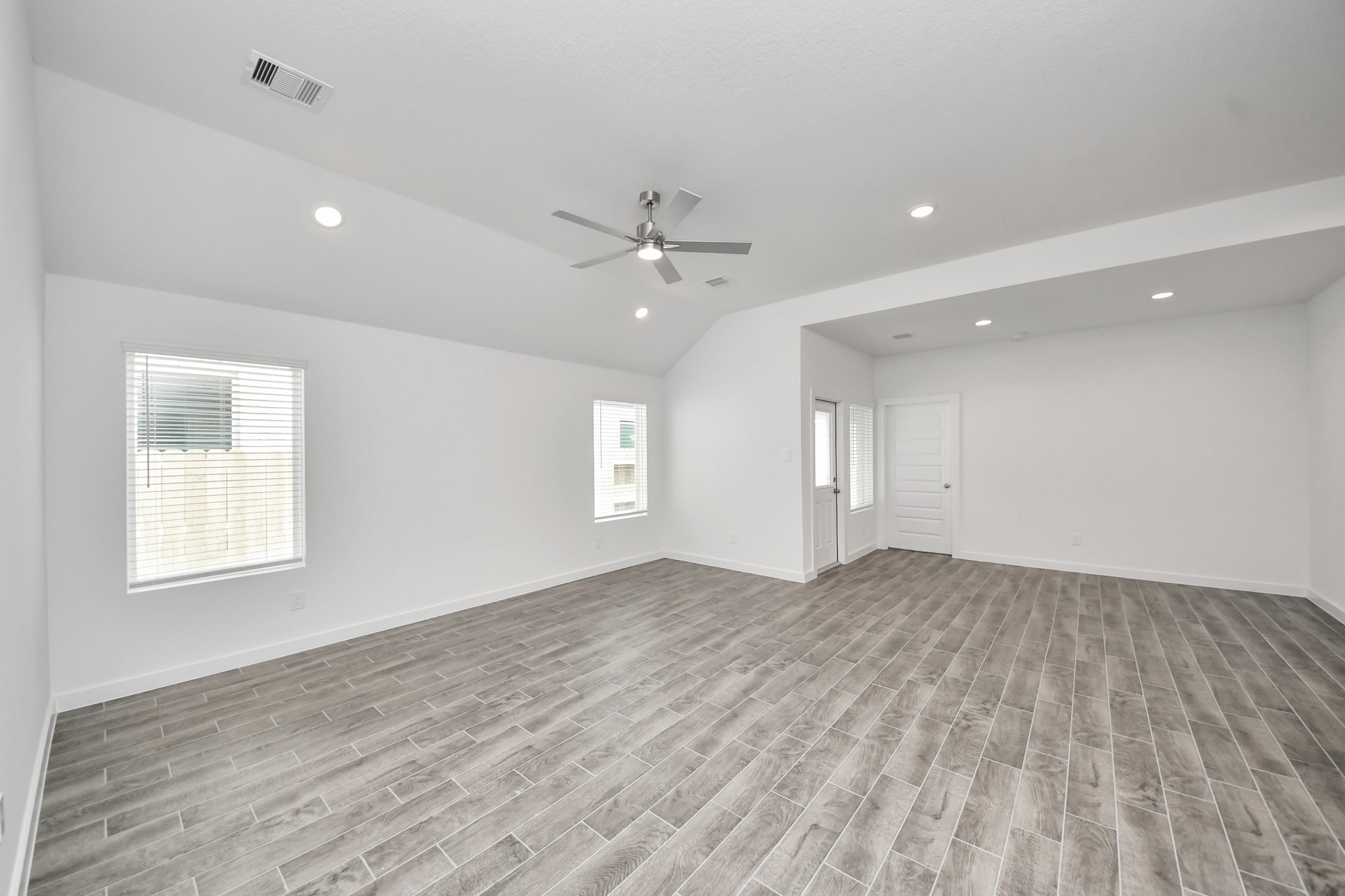 Welcome family and guests to your charming living room! With its high ceilings, recessed lighting, ceiling fan, custom paint, beautiful flooring, and large windows that let in abundant natural light, this room is perfect for gatherings. Sample photo of completed home with similar floor plan. Actual colors and selections may vary.